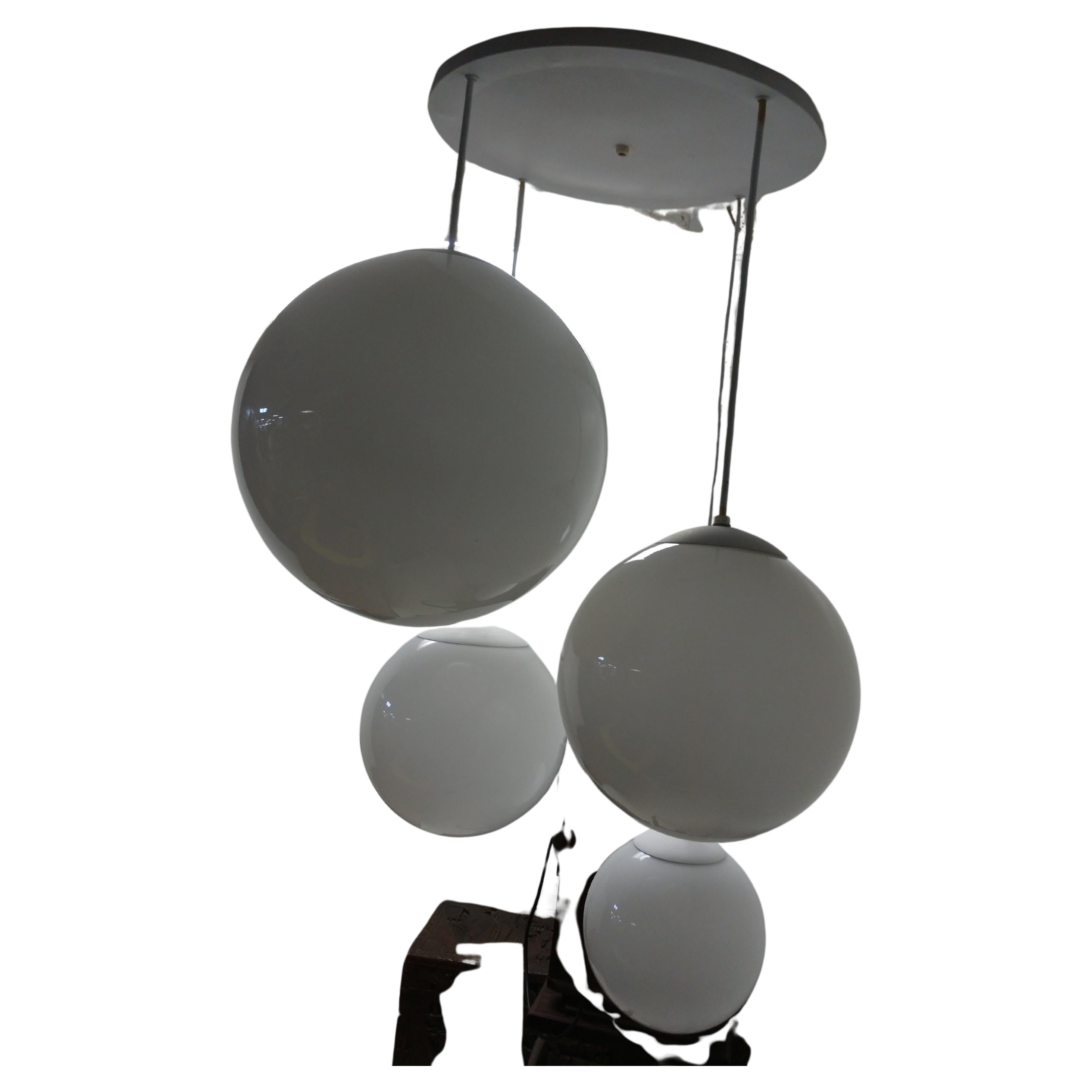 Rare and hard to find pendant chandelier with 4 shades sizes are; 16in. 9in. and 2 11in. Milk glass globes are in excellent condition. A very joyous light fixture. 
Original wiring is sound, not dried out. One globe (11in) has been replaced with