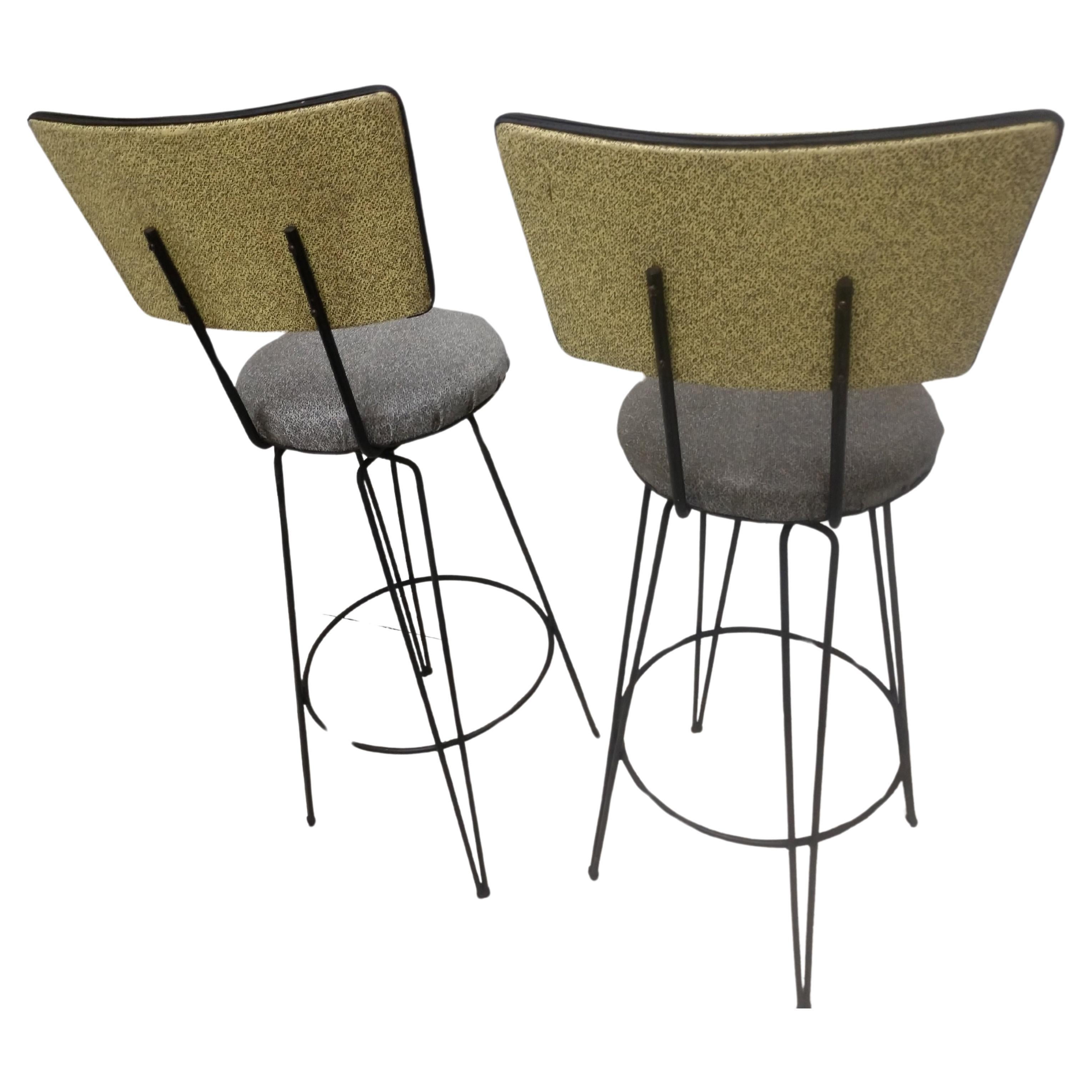 Fabulous 1950s stools with original vinyl fabric, two tone yellow with grey. Have a third which does not have with original foot glides as the pair mentioned. Seat height is 31.5. They swivel freely and are very comfy with a place, bar for your