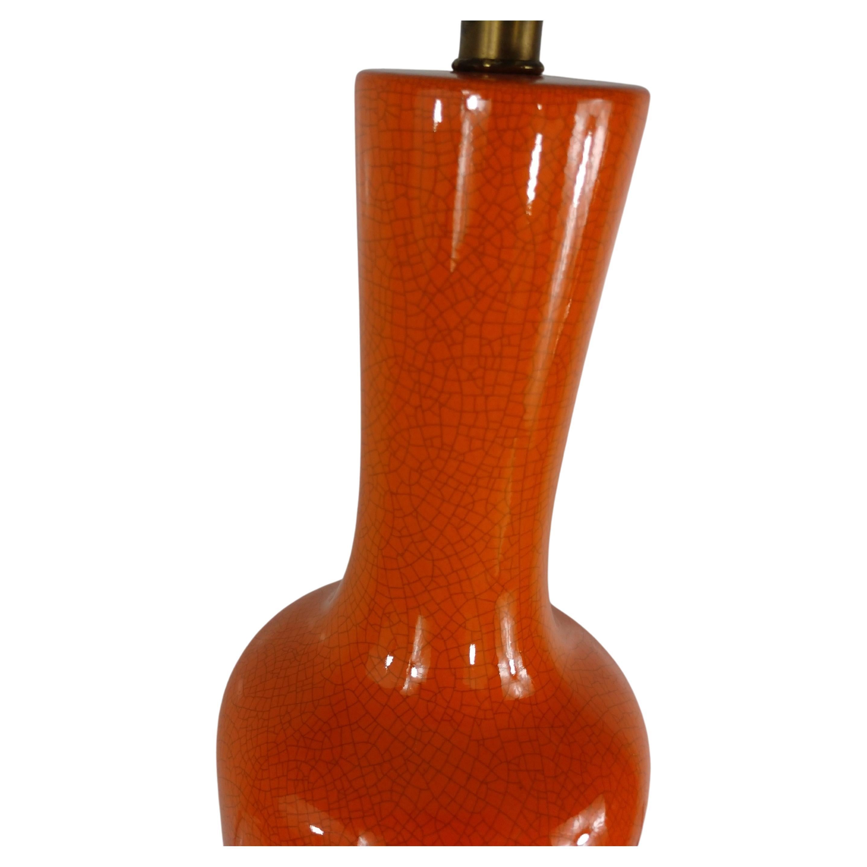Very elegant and subtle striking pair of mid century lamps. Orange crackle glaze is simply beautiful in a sculpted bottle form. Brass fittings for accent. Shades are 16.75 x 11 H included. 25.75 is the height to top of the socket. In excellent