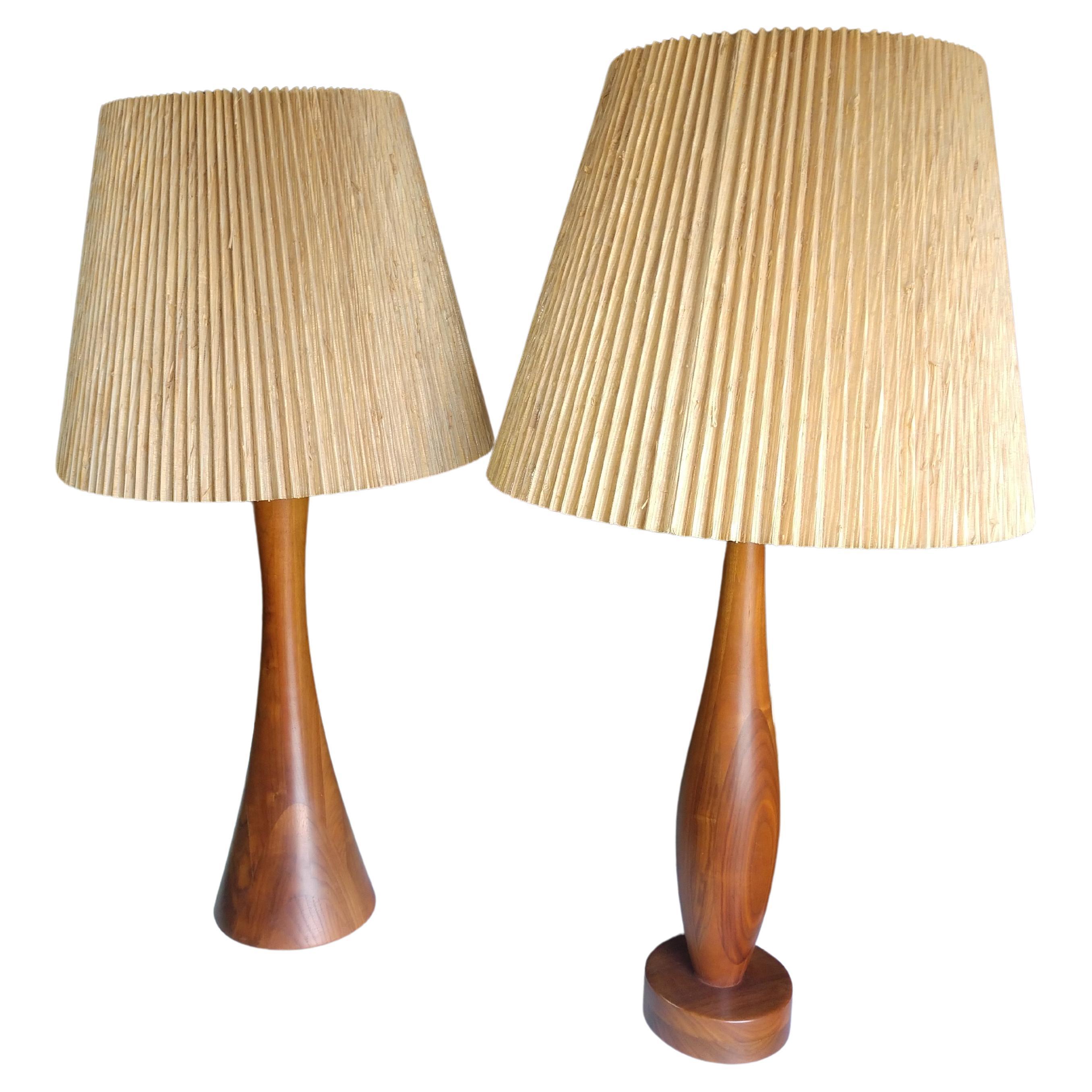 Fantastic pair of complimentary sculptural walnut table lamps designed by Philip Lloyd Powell in New Hope Pennsylvania. Shades seem to be original, hgt with shades is 37 with a 19 inch diameter at bottom of shade. Height to top of socket is 27 inch.