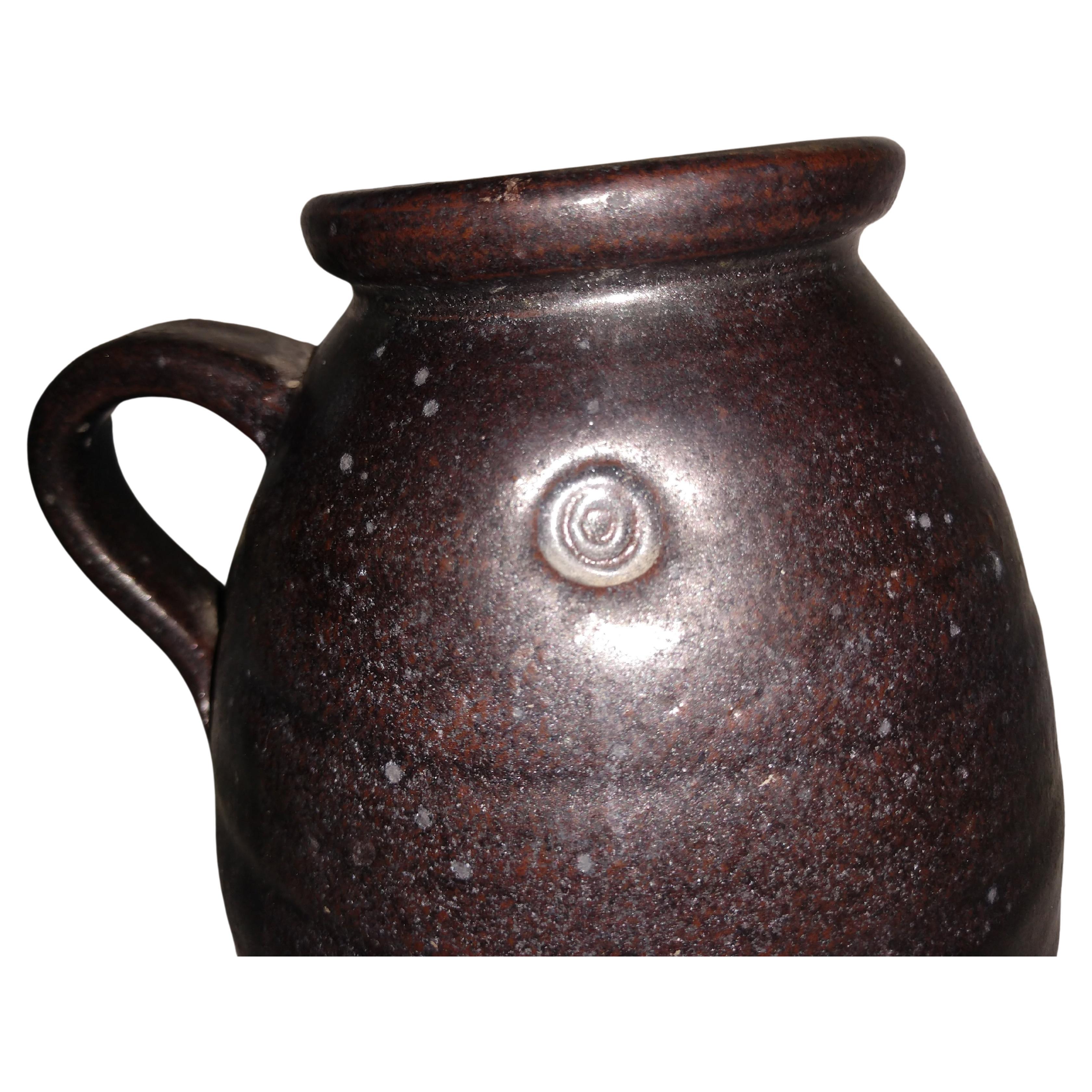 Beautiful arts & crafts brown glaze jug vase with a handle by Herbert Sargent. Hand thrown with precision and glazed with the potter's touch. Herbert Sargent was a television and movie writer who worked on the Johnny Carson Show and Saturday Night