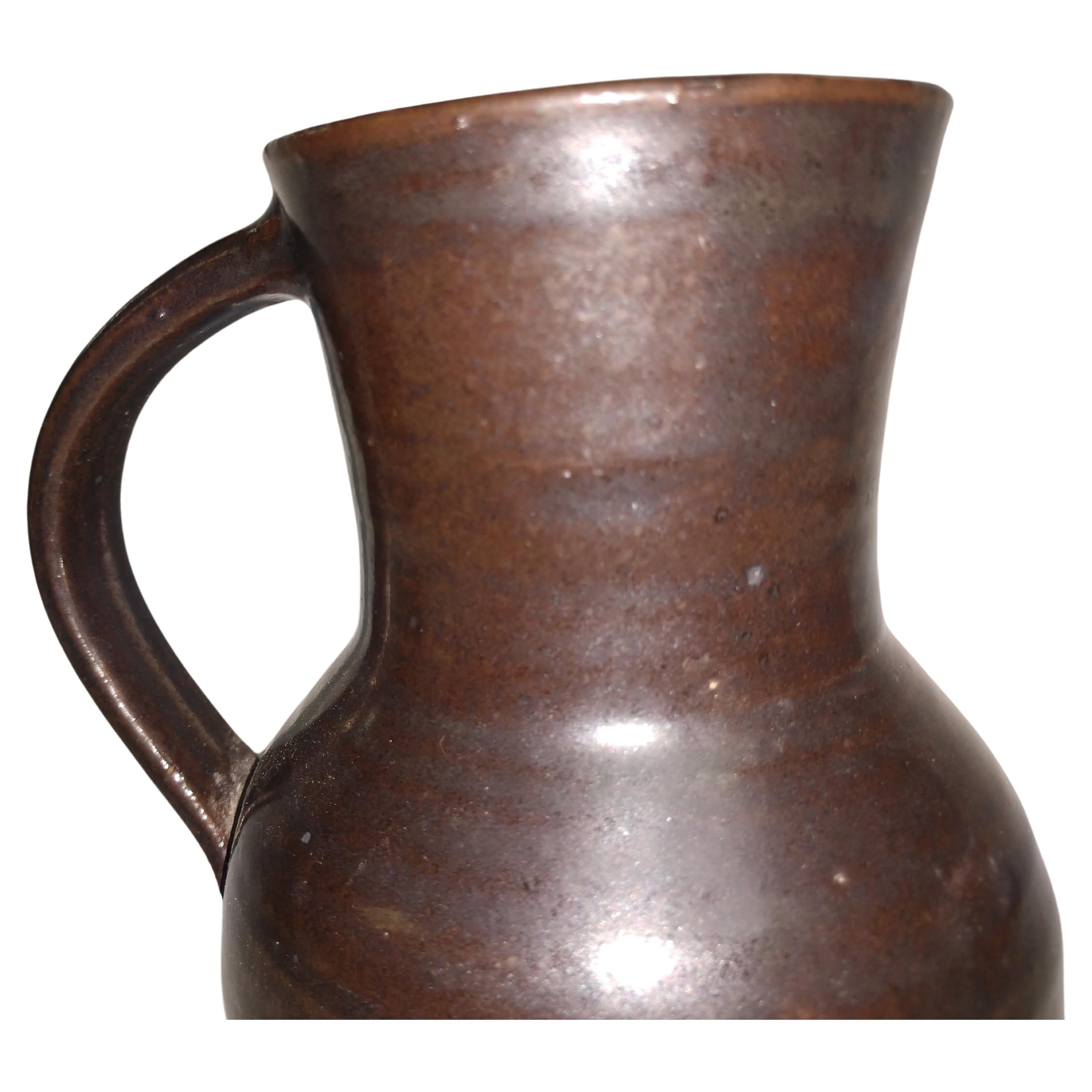 Fabulous hand thrown vase Jug with a deep brown glaze by Herbert Sargent.
Large handle gives it the look of a pitcher. A beautiful piece by Herbert Sargent who was a TV and movie writer who worked on the Johnny Carson Show and Saturday Night Live.