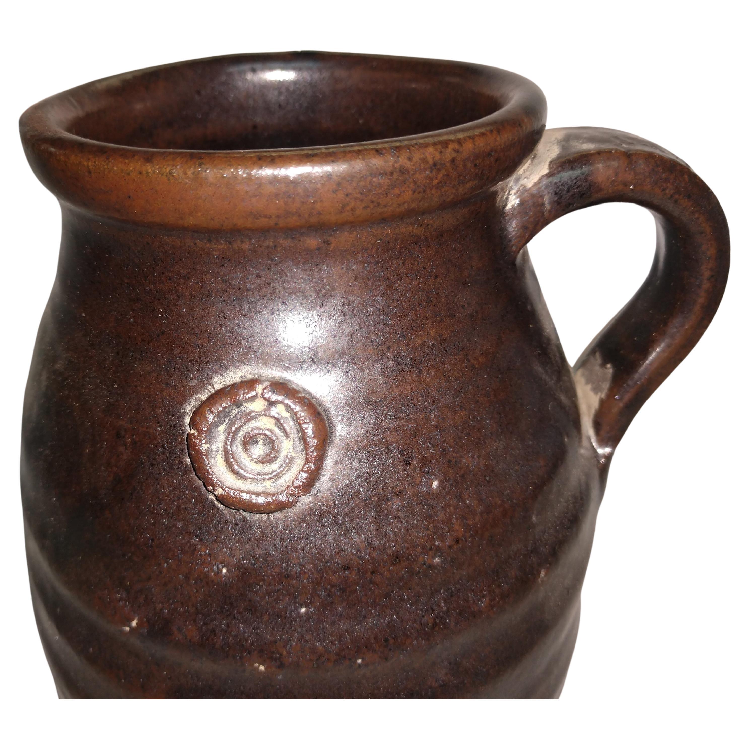 Fantastic piece of hand thrown pottery by Herbert Sargent. Ribbed with a small handle and his signature buttons in a fabulous deep brown glaze. Herbert Sargent was a TV and Movie writer who worked for such shows as Johnny Carson Show and Saturday