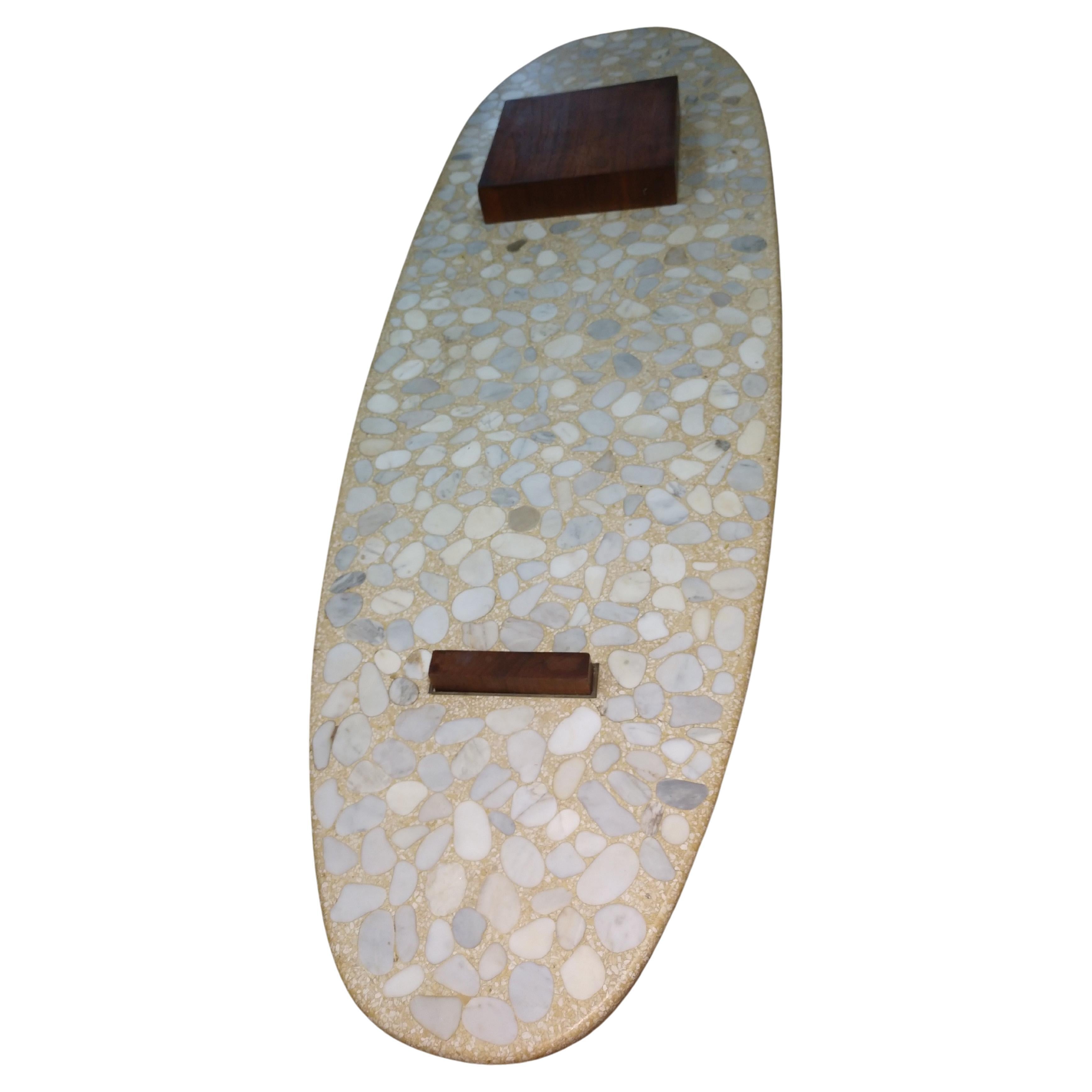 Fabulous Terrazzo table with walnut blocks pierced through. Surfboard shaped table is 1.5 inches thick.  In excellent vintage condition with minimal wear. Top does have a few very minor non structural superficial cracks.