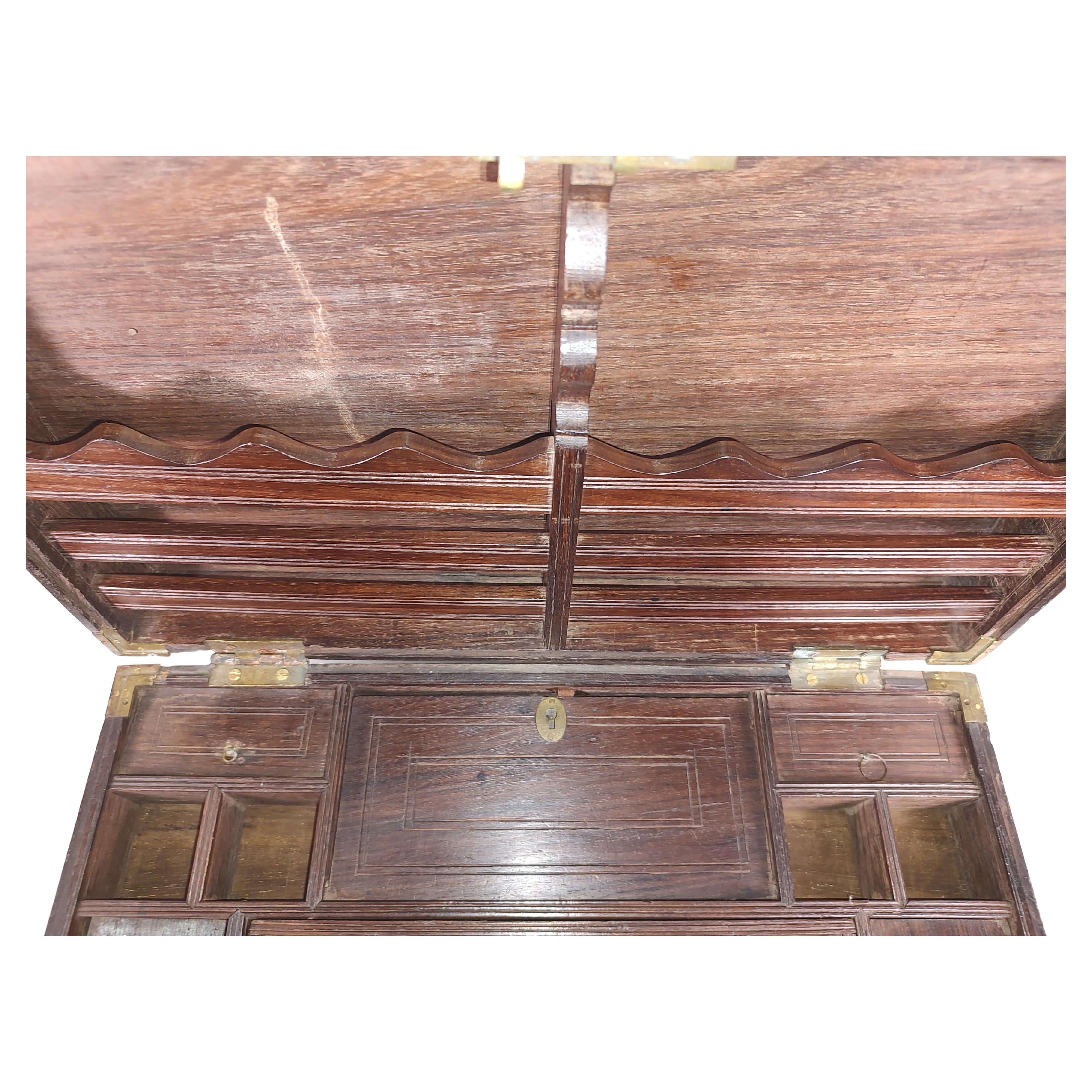 Fabulous and large rosewood and teak fitted letter writing box with brass inlay. Numerous cubbies with lids for various items. Slotted back panel for paper. Brass handles and a working lock and key. In excellent antique condition with minimal wear.