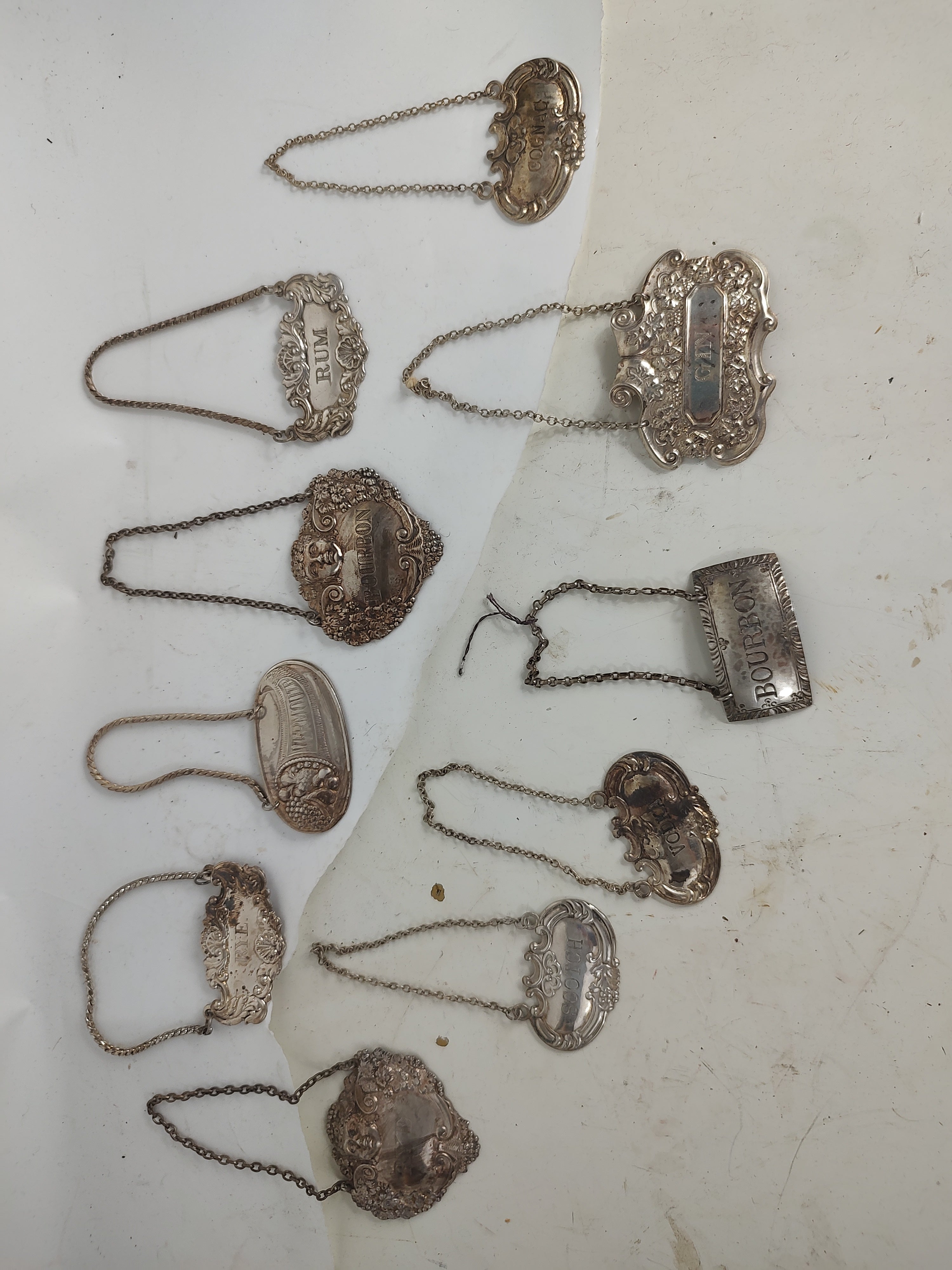 Magnifiques badges en argent sterling pour les carafes à vin et à liqueur. Marqués en argent, certains avec des poinçons, deux marqués made in Spain. Ils vont du gin au rhum, en passant par le bourbon, le seigle, le vermouth, la vodka et le cognac.