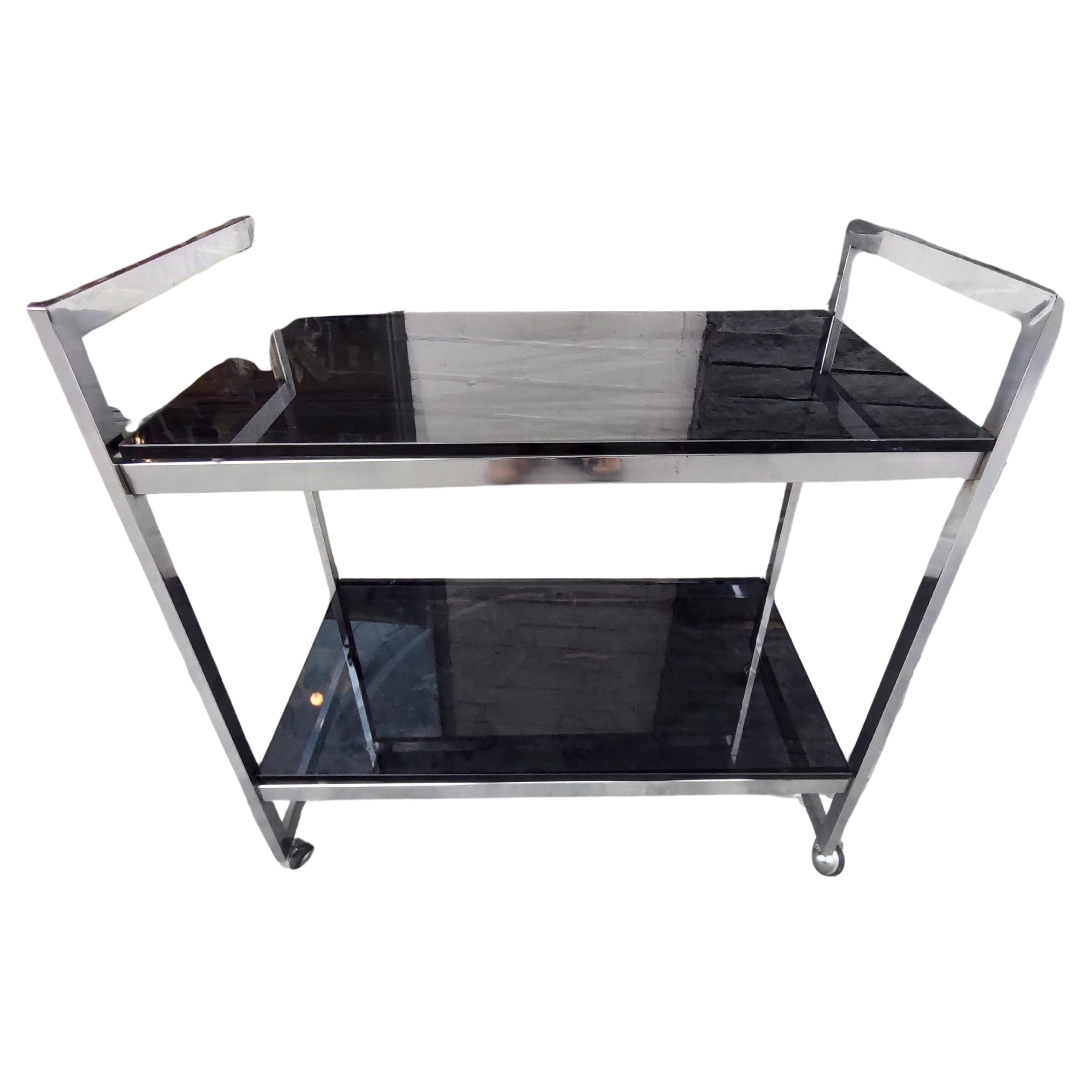 Simple and elegant chrome with black Glass bar cart. Clean straight lines keep it simple, minimalist approach is the key to the design of this bar cart. Flat bars with chromed and rubber wheels, this cart has no issues with movement. Heavy thick 1/2
