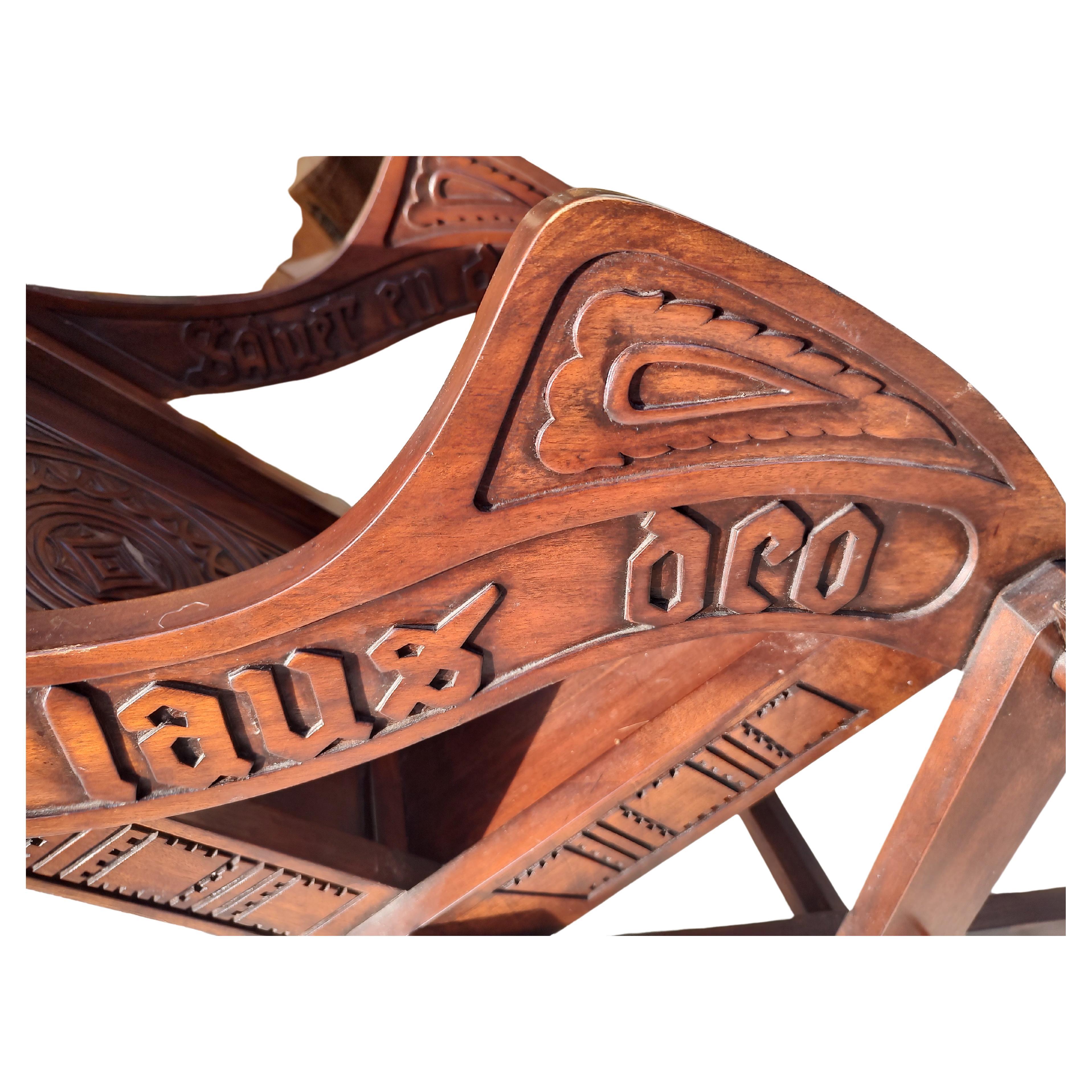 Fabuleuse paire de fauteuils Glastonbury richement sculptés en acajou. Des inscriptions en gras ornent les deux côtés des accoudoirs et l'intérieur du dossier des deux chaises. L'inscription est accompagnée de symboles celtiques. Toutes les pièces