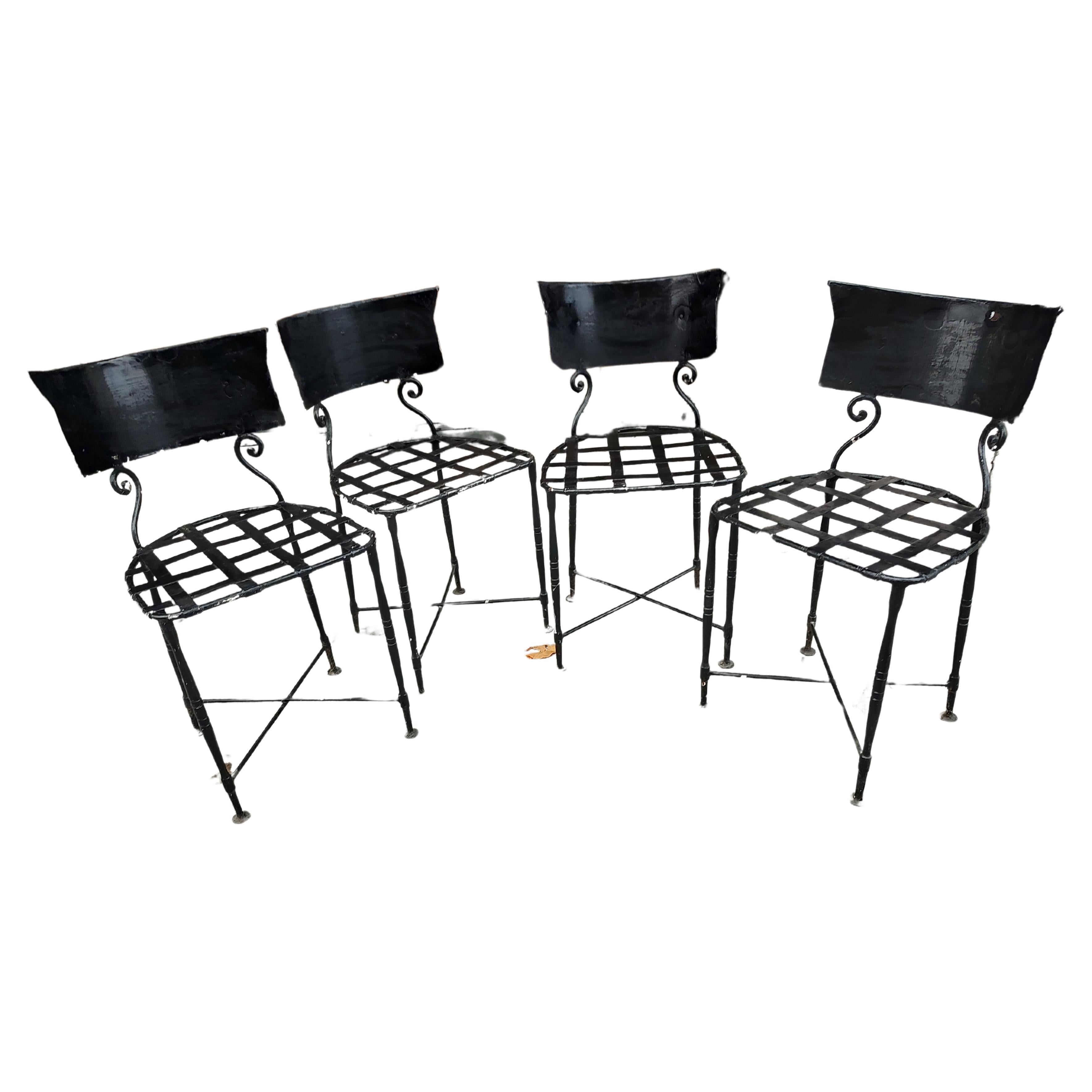 Fabulous and a very special set of 4 hand crafted French Iron outdoor patio garden chairs. Hand wrought with charming round legs, strap seats with scroll work connecting the curved solid seat backs. Cross stretcher for stability. Multiple coats of
