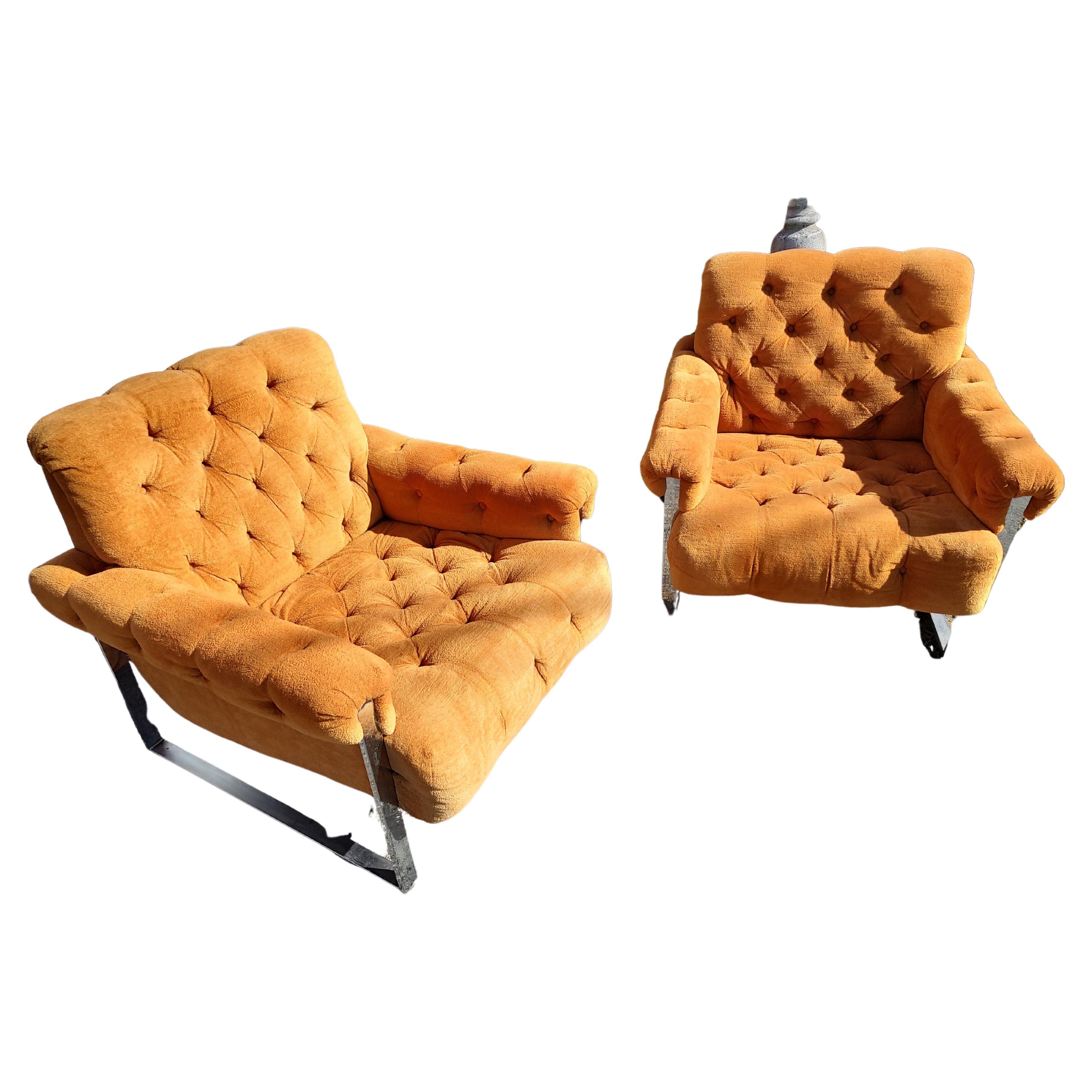 Paire de fauteuils de salon touffetés de boutons à base orange et chromée