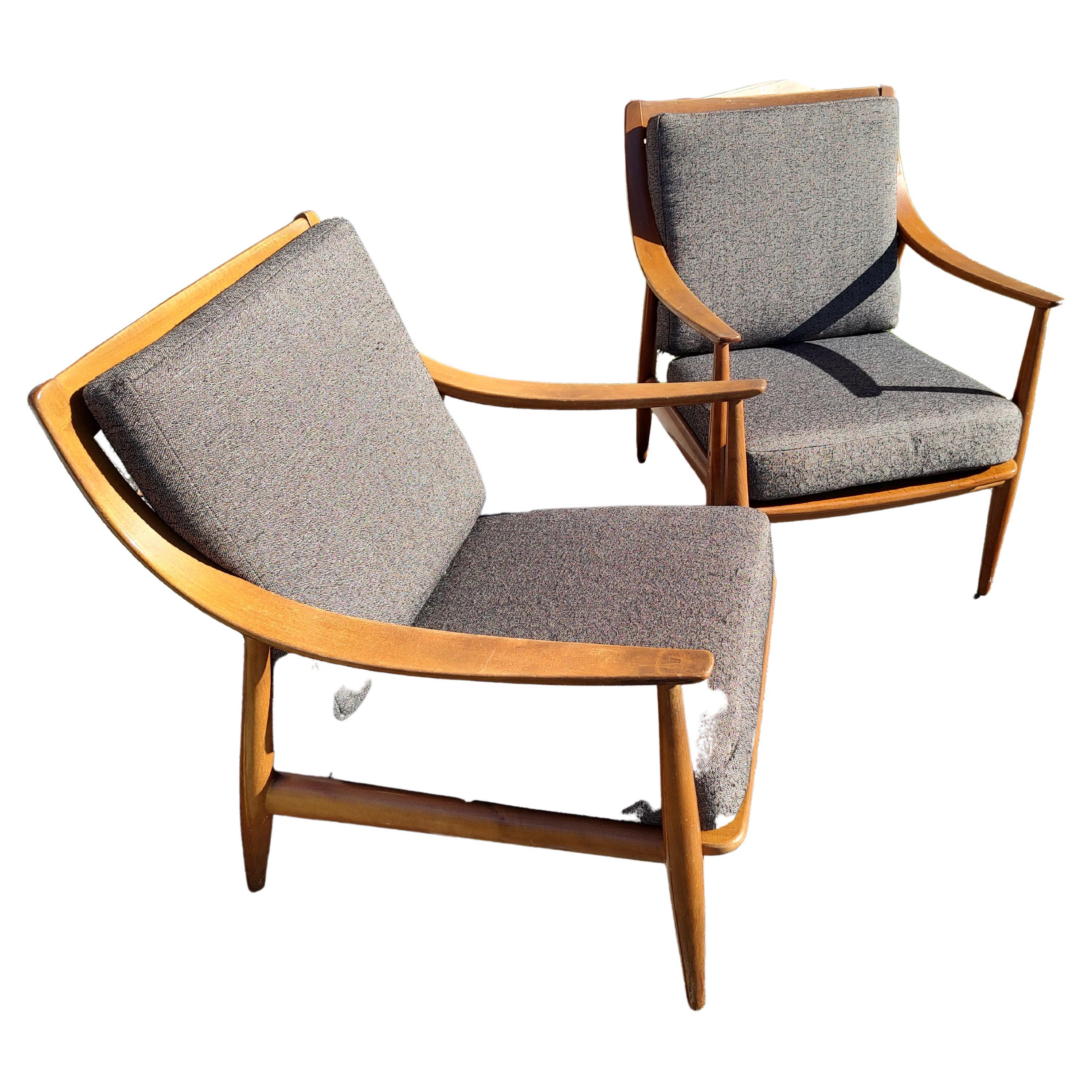 Beautiful pair of Mid-Century Modern sculptural Scandinavian designed chairs by Peter Hvidt and Olga Molgaard Neilson for John Stuart Inc. Created out of walnut with sloping curved arms and spindle backs. Brand new upholstery gives a great look and