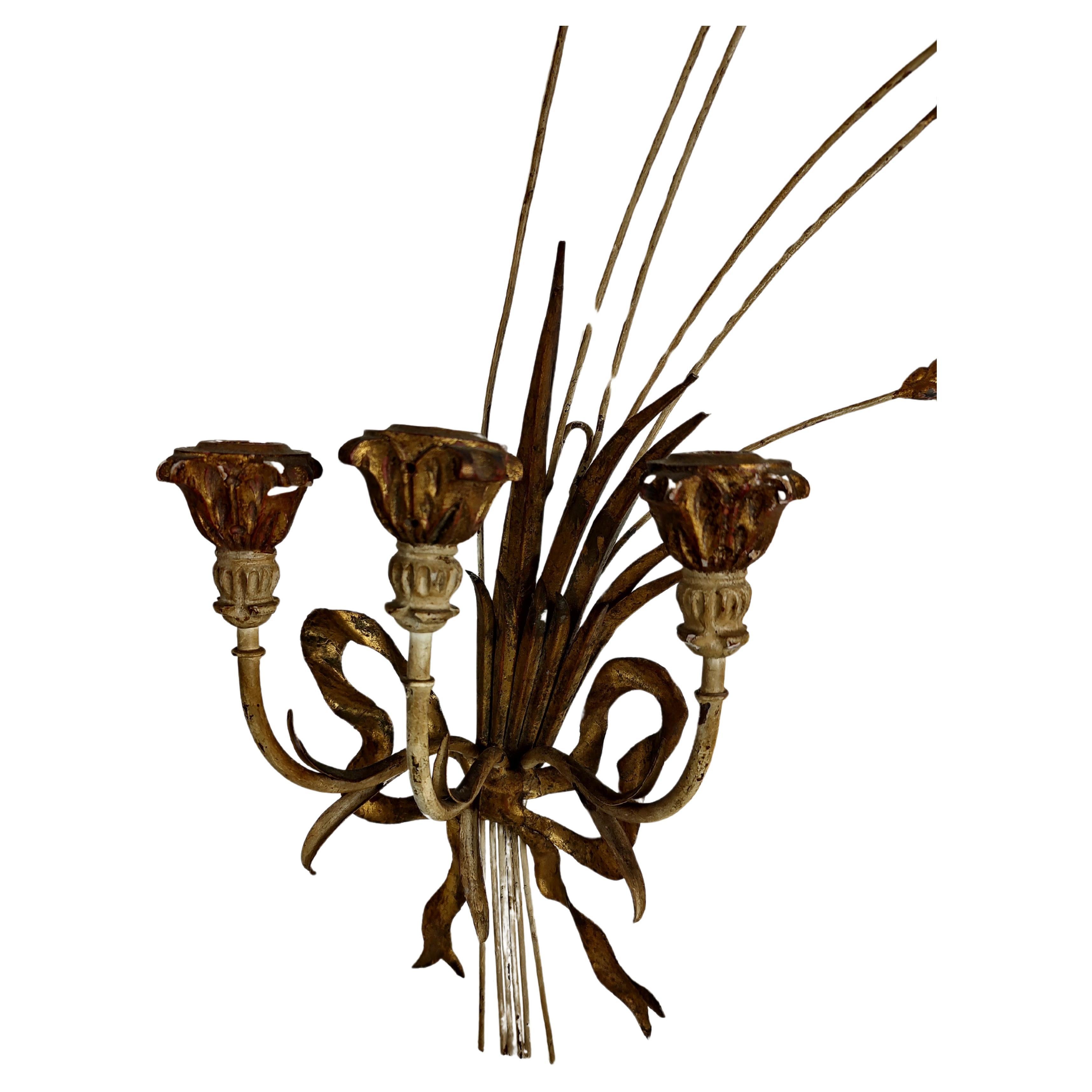 Simple and elegant pair of Hollywood regency gilt sheaf of wheat candle sconces with a bow tie banding it together. In excellent vintage condition with minimal wear. Sold as a pair each sconce has three candle holders. This is not electrified.