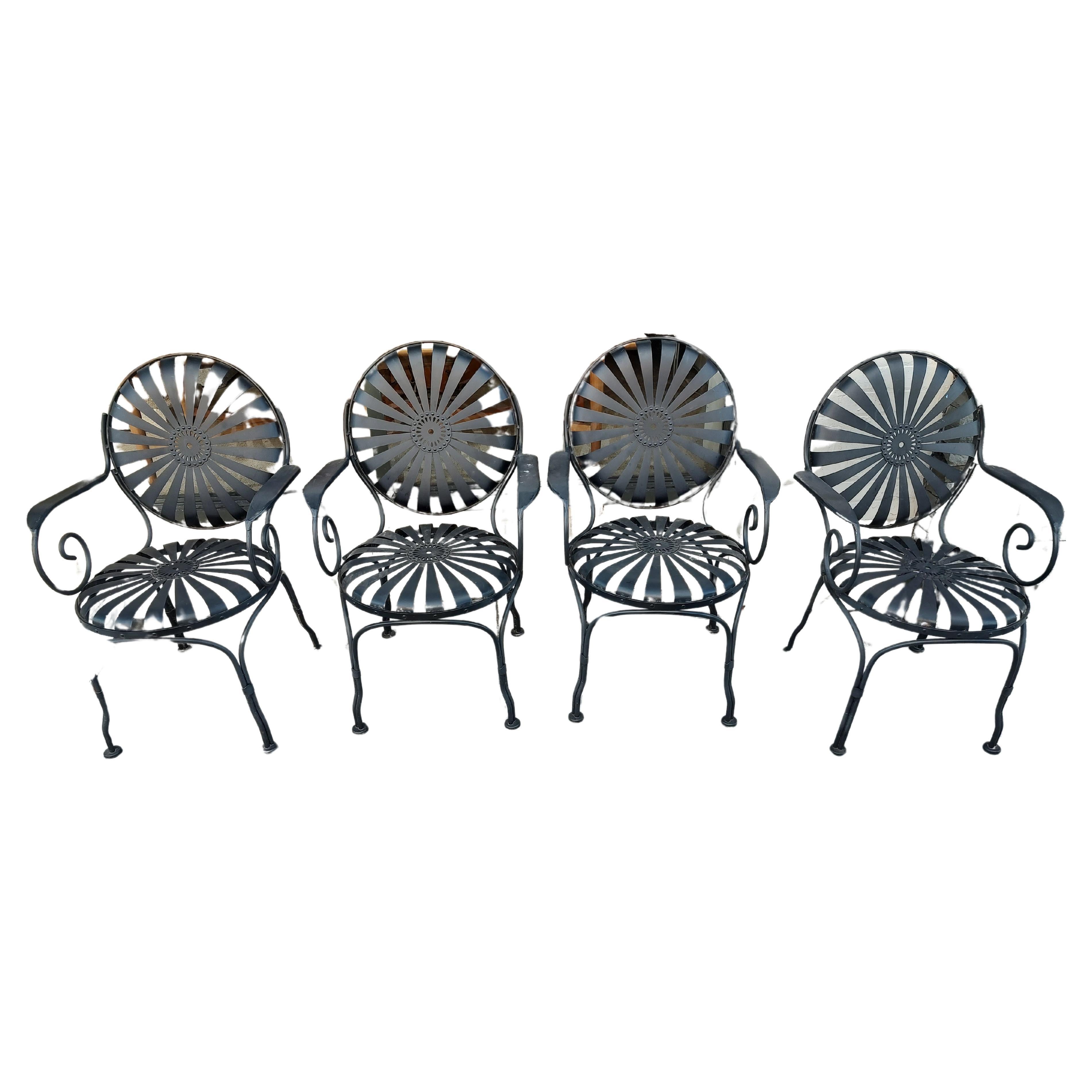 Fabulous set of 4 French iron armchairs in the style of sunburst or sunflowers with spring steel seats and backs. Restored about 4 yrs. ago and kept in an enclosed porch since. Bits of rust on undersides of the seats. No structural damage or bad