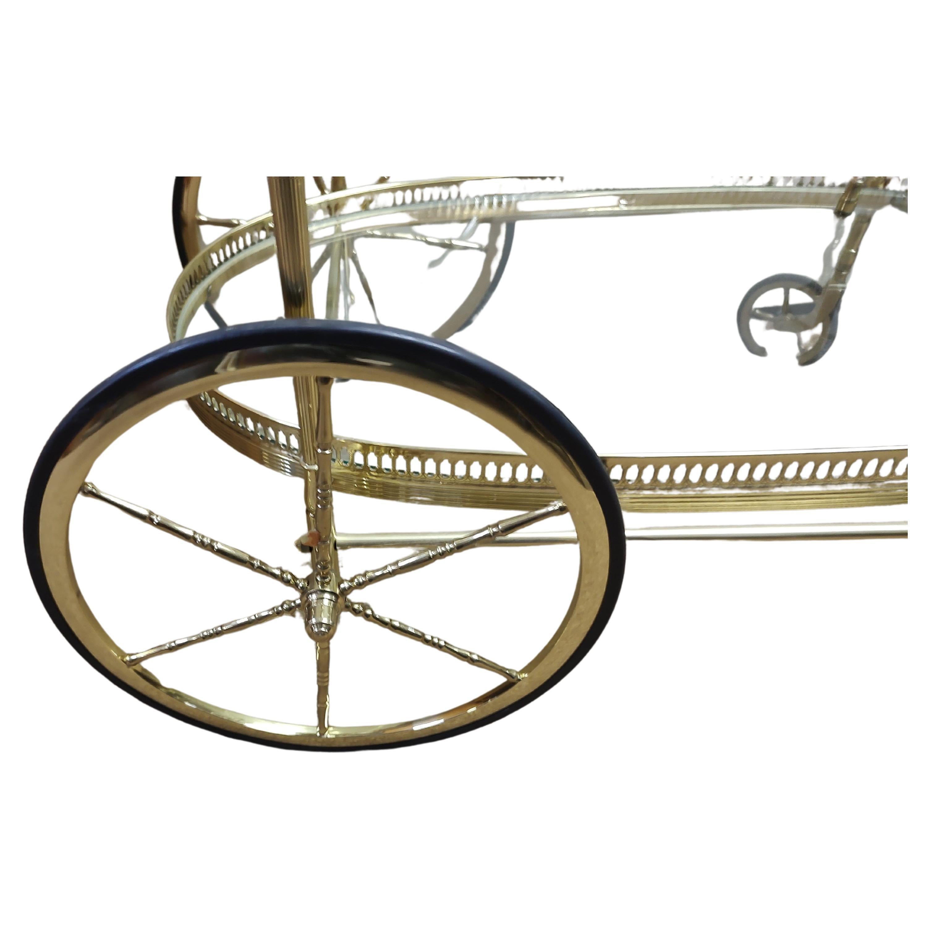 Wunderschöner Barwagen aus poliertem Messing. Toller Stil und in ausgezeichnetem Vintage-Zustand mit minimalen Gebrauchsspuren. Netzartige Bänder entlang des Umfangs mit ausgefallenen Beinsäulen. Flaschenhalter auf der unteren Ablage. Große runde