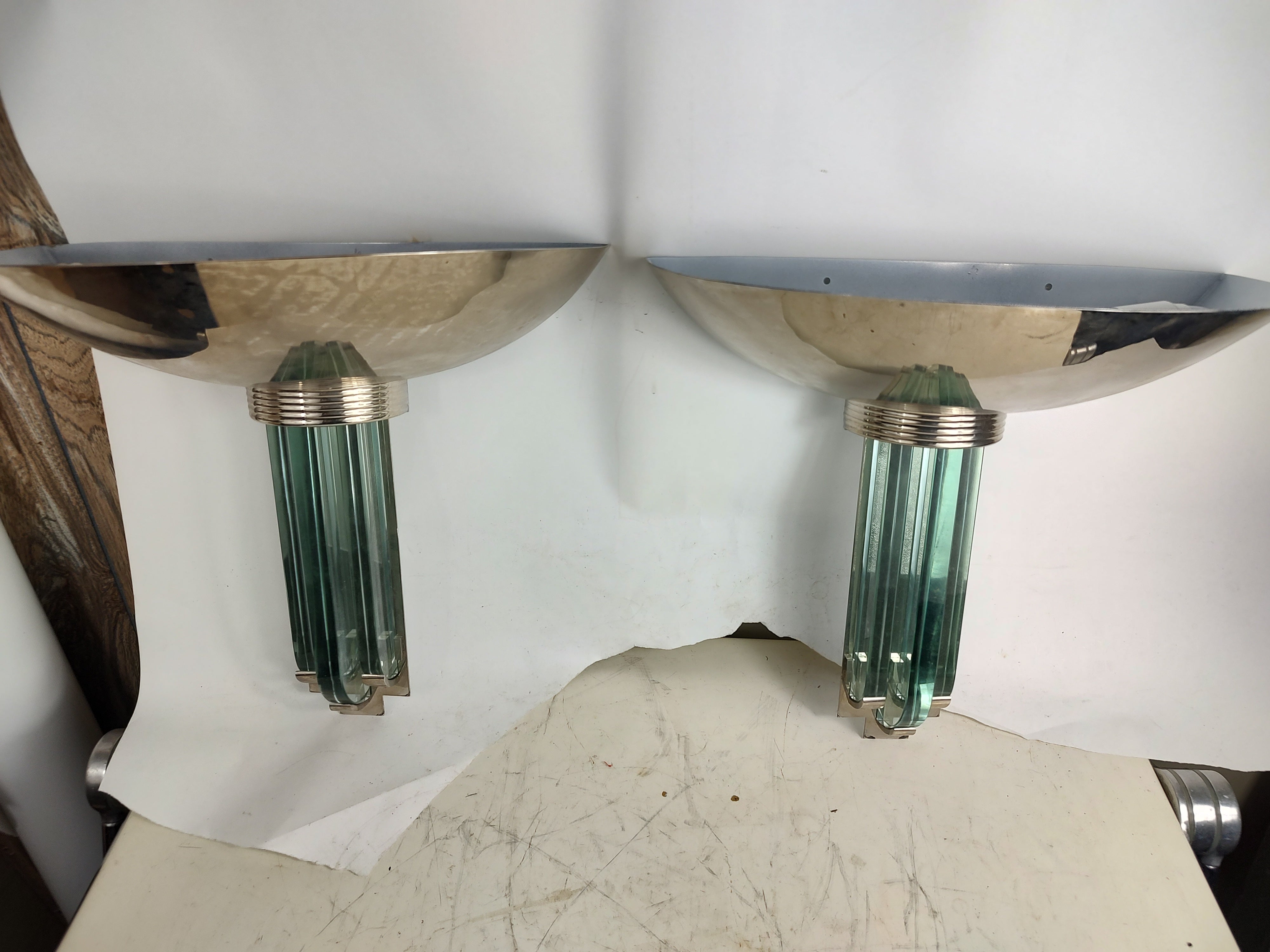 Fabulous simple yet elegant pair of high quality Art Deco styled wall sconces. Heavy thick glass in a vertical position supporting a large chrome dish with two incandescent sockets supplying the illumination. In excellent vintage condition with