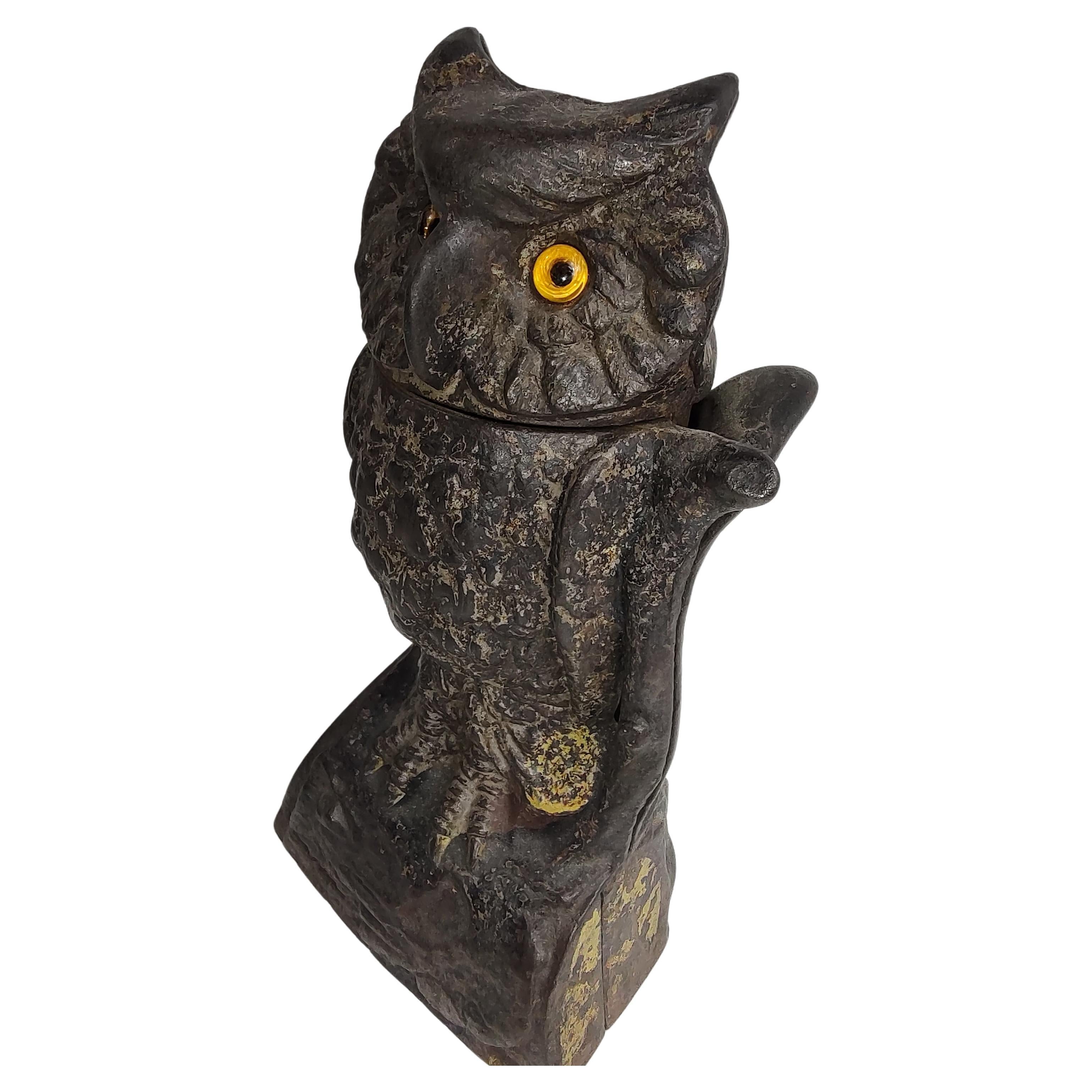 Fabulous cast iron Owl bank with a turning head coin lever and glass eyes. Lot of the original paint still intact. Missing the lock on the underside, not visible when viewing upright. In excellent antique condition.