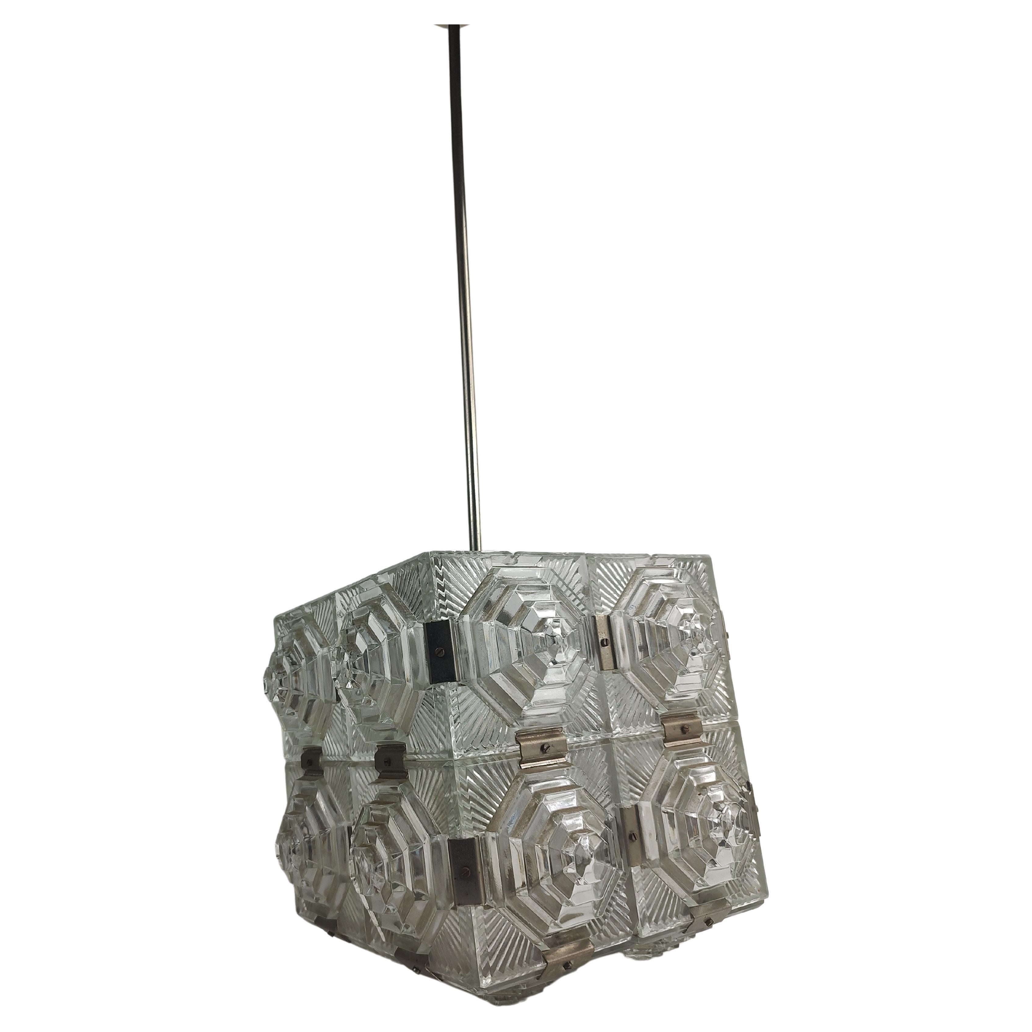Fabulous and a rare stylized Art Deco chandelier in a cubist form. Four panels locked together create each side and bottom. Patterned on all 4 sides and the bottom this lamp creates a prism effect when lit. Nickel chrome hardware connectors lock all