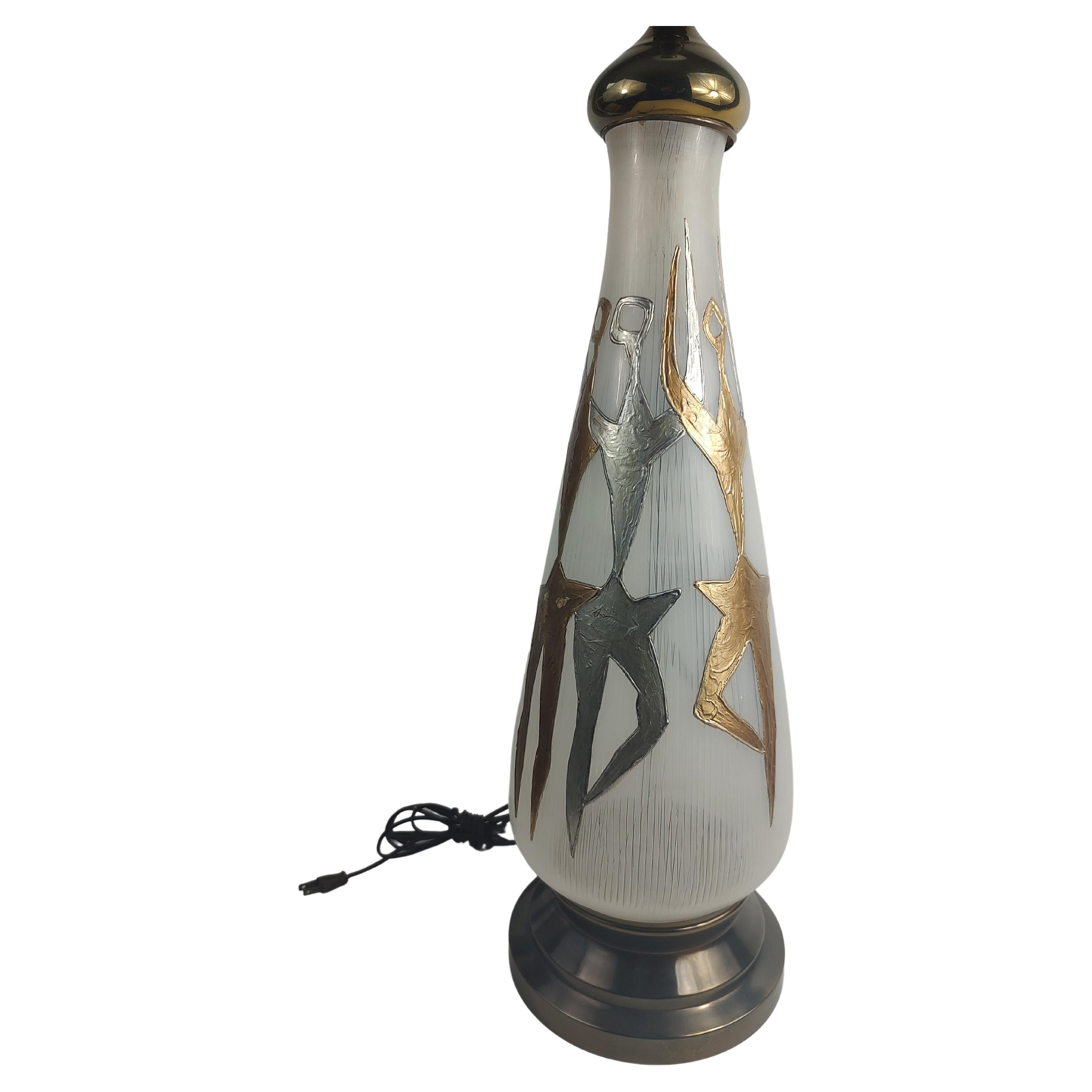 Fabulous stylized glass table lamp with modern dancers in gold and silver. Milk glass diffuser sits atop brass stem. In excellent vintage condition with minimal wear. Includes pictured shade which is intact but in delicate condition.