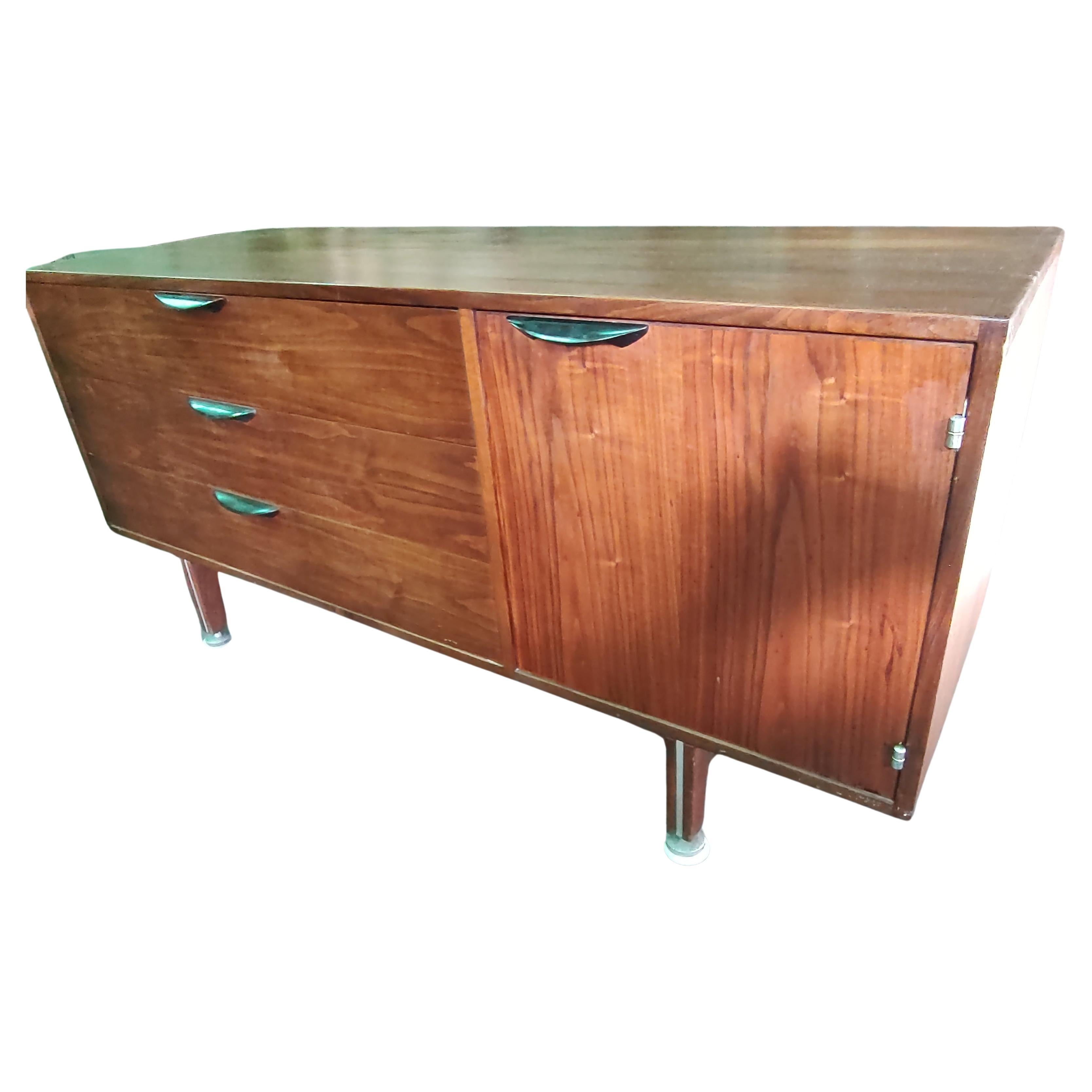 Fabulous Mid-Century Modern credenza by Jen's Risom. 3 drawers beside a cabinet door with 1 shelf. Solid Walnut with a finished back. Aluminum hardware with inlay in the legs. Oak secondary woods for the drawers interior. Ebonized sculpted metal
