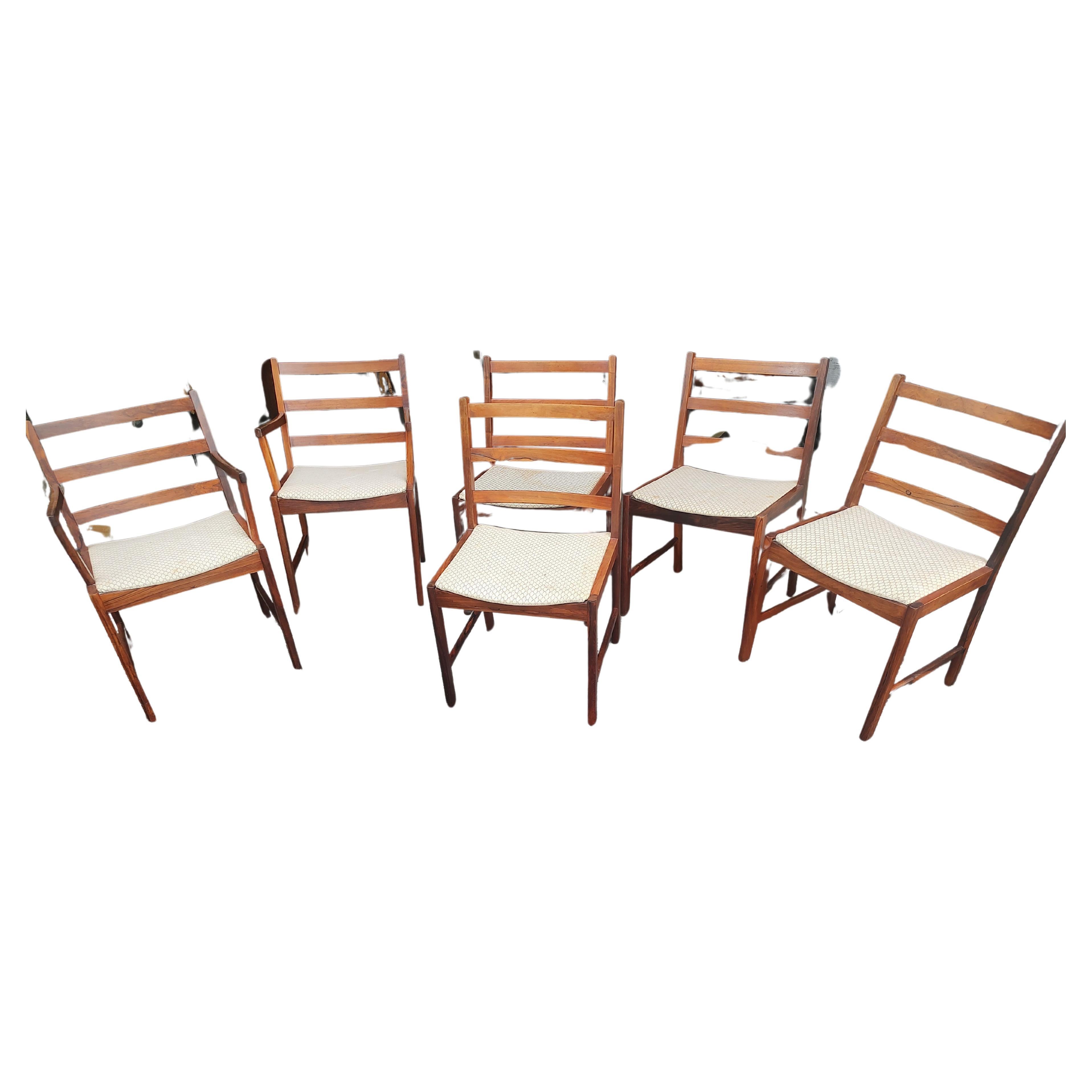 Fantastic set of very elegant and simple dining chairs with ladder backs and generous seats created from Rosewood. Late sixties and in excellent vintage condition with minimal wear. Seats need recovering, four screws holding them in place makes for