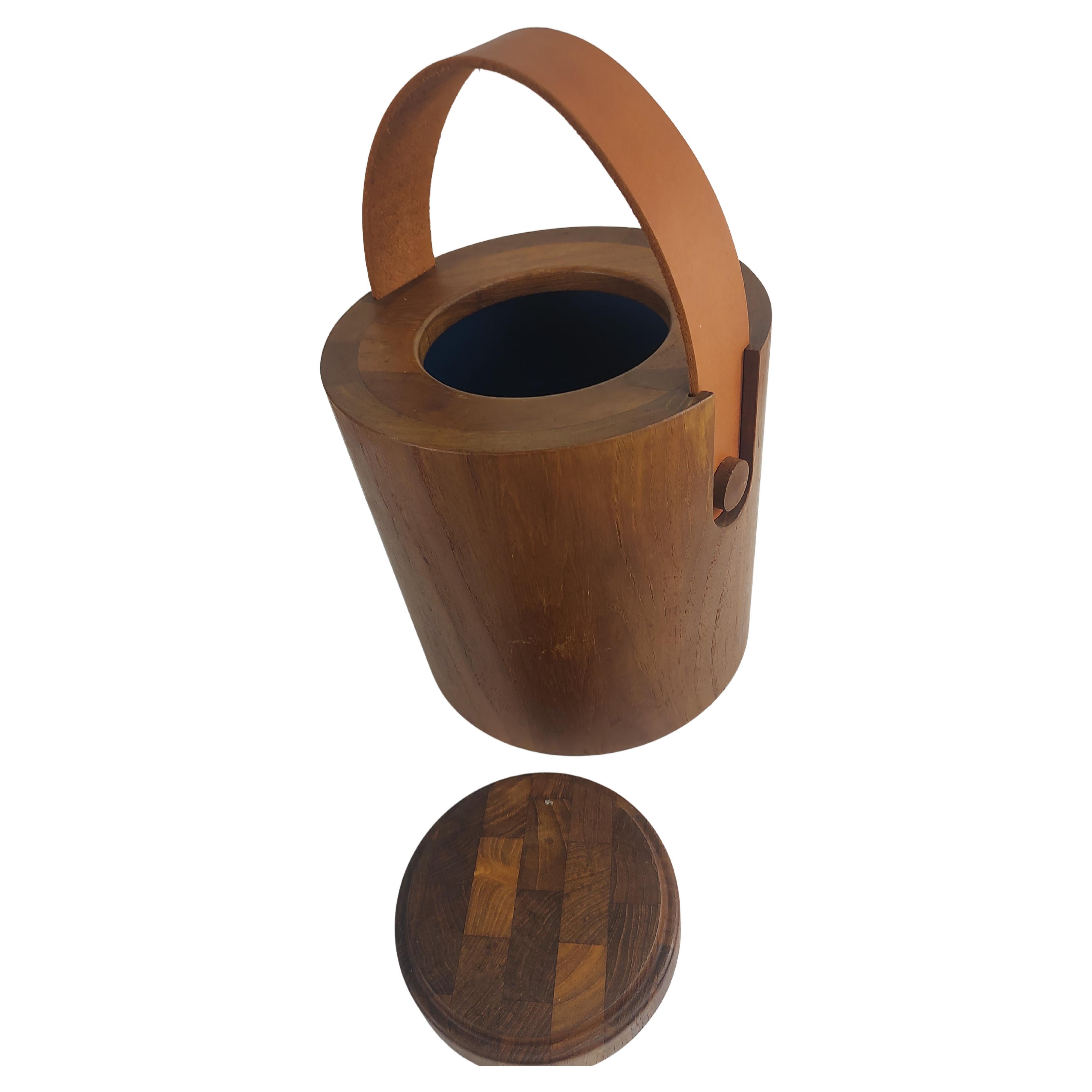Fabulous simple and elegant teak ice bucket by Nessen with a thick rigid new leather strap handle. Plastic liner with a lift off lid in excellent vintage condition with minimal wear. Signed on base see pics.