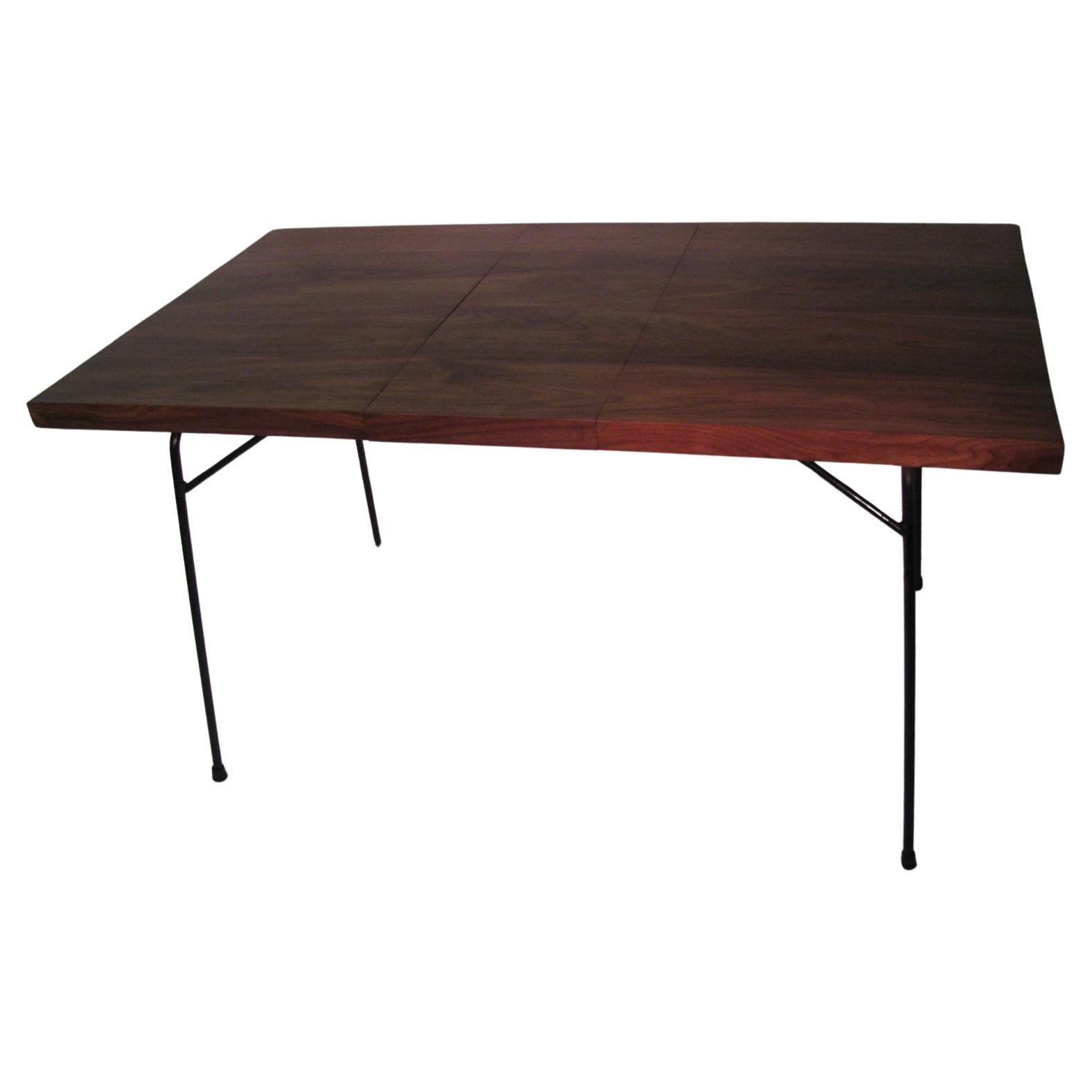 Beautiful and newly created black walnut top with leaf. Figural walnut grain with the leaf also. Walnut sits atop original black iron base. 1.5 inch apron surrounds the edge of the table. Leaf is one foot wide. Table is 42 in. without the leaf. In