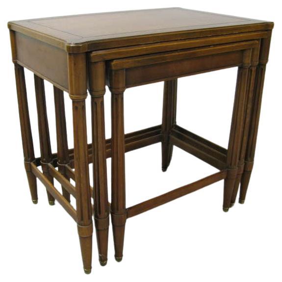 Beautiful classically styled nesting tables. Reeded column legs with stretchers that band around legs. Tables slide effortlessly into one another. Generous proportions make tables very practical. Brass sabots cap the feet. Middle table dims are, 22