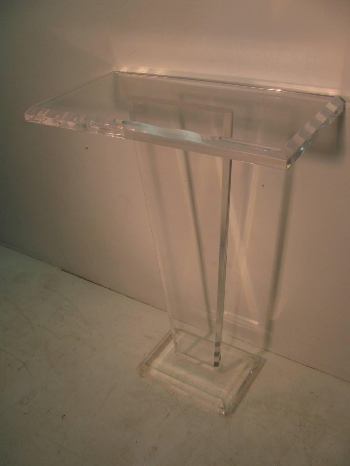 Simple and elegant Lucite pedestal with a tapered form and a large shelf, 28 x 14. All edges are beveled. Lucite is 1.5 inches thick. Base is 10 x 14. Lucite is clear, not yellowish as in the photos.