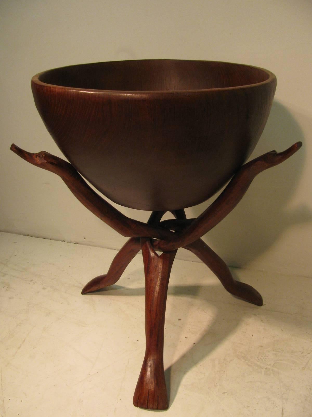 Fabulous teak plant stand and bowl which consists of a figural stand that is hand-carved and interlocked. Animal faces and feet carved into the base. Large bowl snugly sits in the cradle. Bowl is 15 W x 8 D.