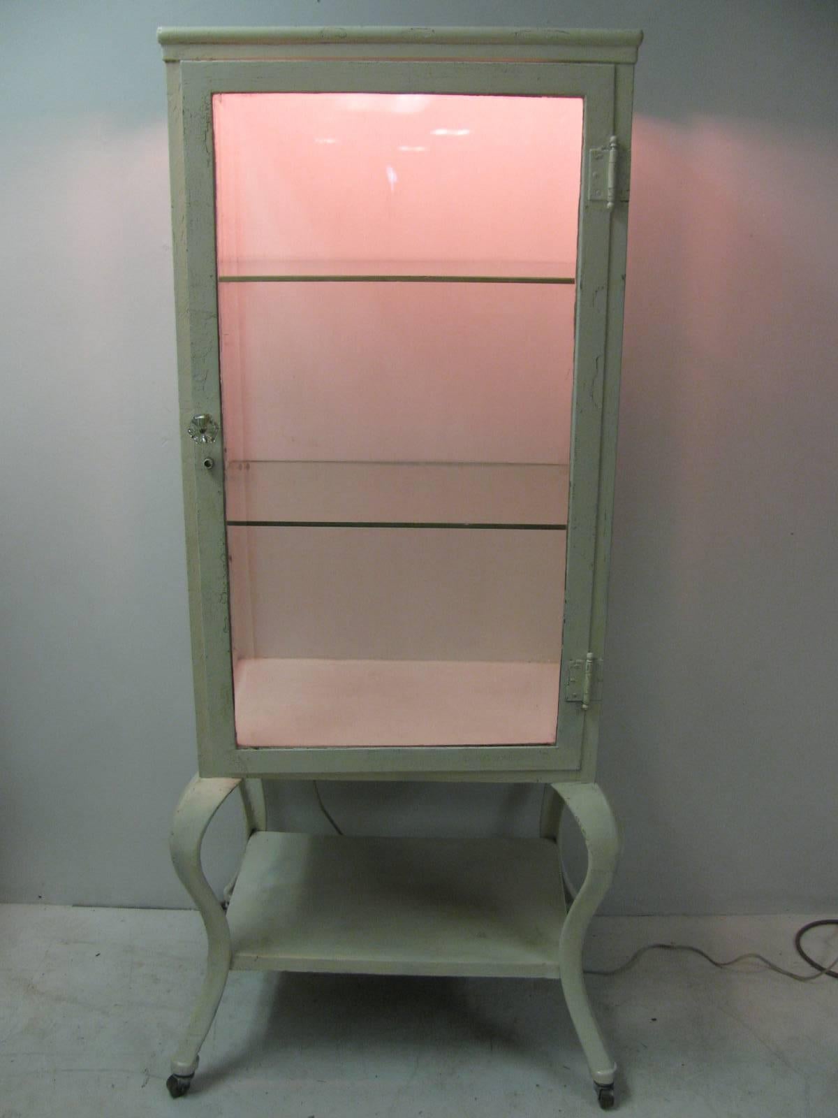 Beautiful cabinet with bow cabriole legs, 1 and 1/4 inch beveled glass on all three sides, caster wheels and it lights up with hidden twin sockets. Pair of 1/4 inch thick glass for the shelves. Cabinet was lightly sanded and sprayed shell white and