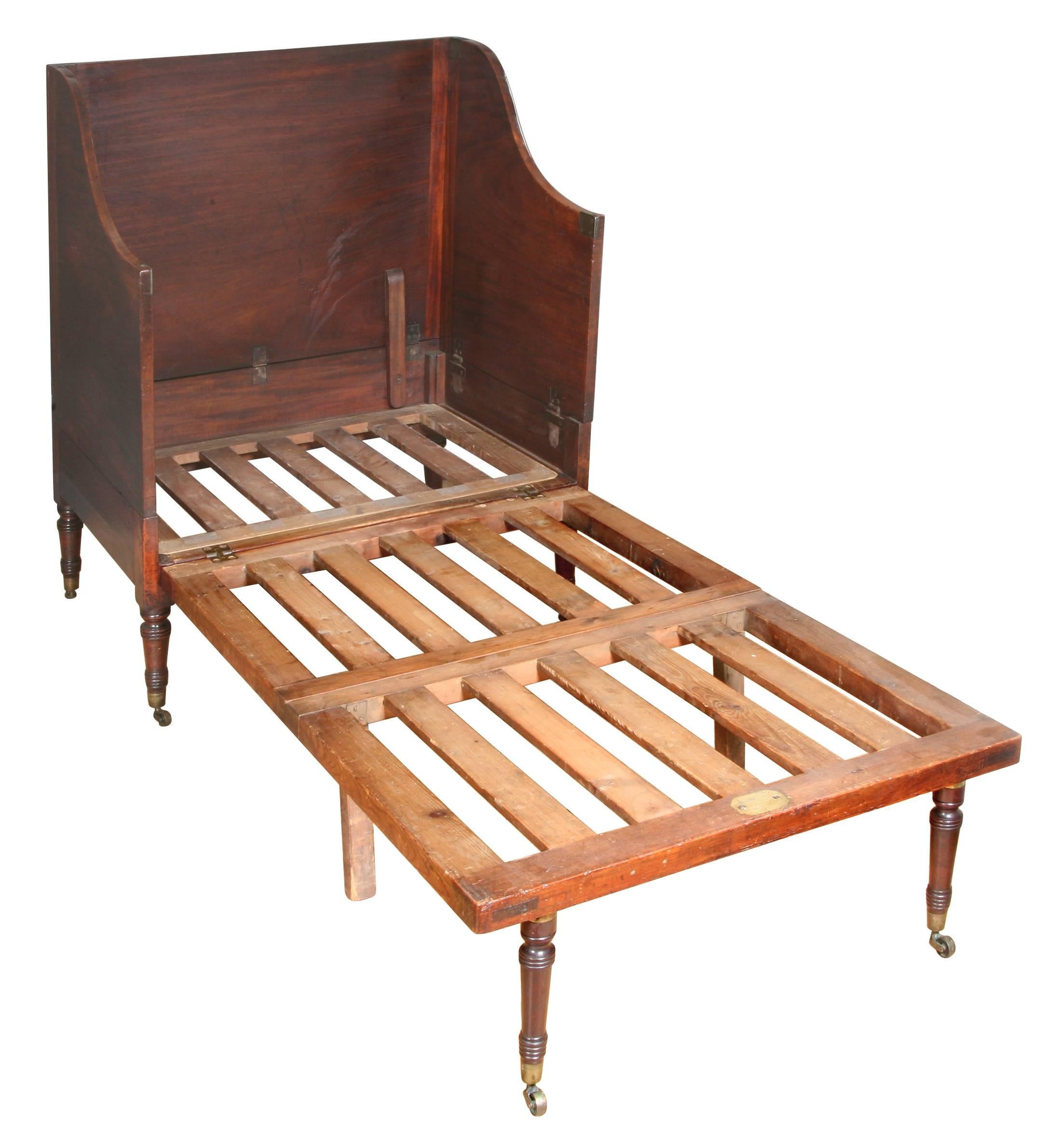 This mahogany chair bed is a design commonly associated with the Catherine Street makers of Thomas Butler and Morgan and Sanders. The pine frame folds out to convert the chair to a bed with a pair of turned legs screwed into the end to support it.