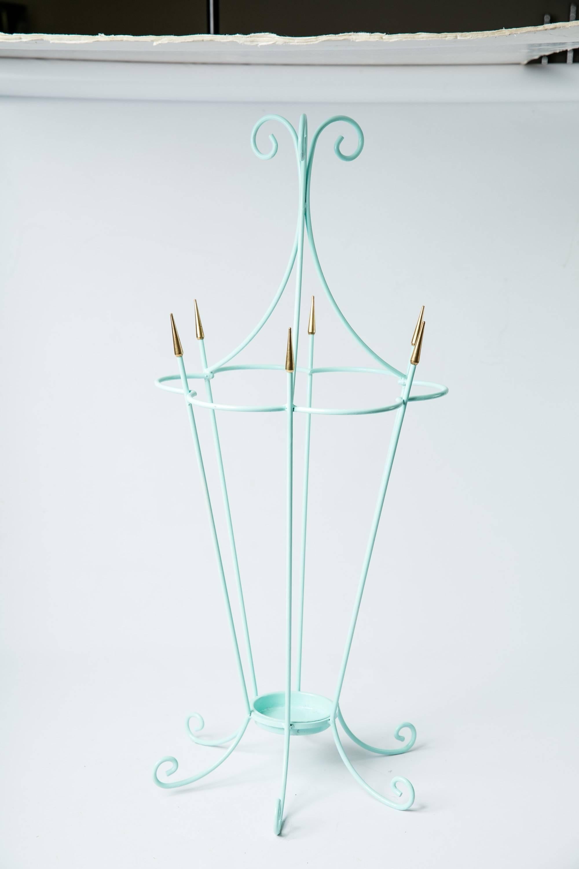 A beautiful 1950s English Mid-Century umbrella stand. The Stand is painted a soft shade of blue and features brass arrow-like tips and curlicue feet. Very Festival of Britain. Removable drip tray.