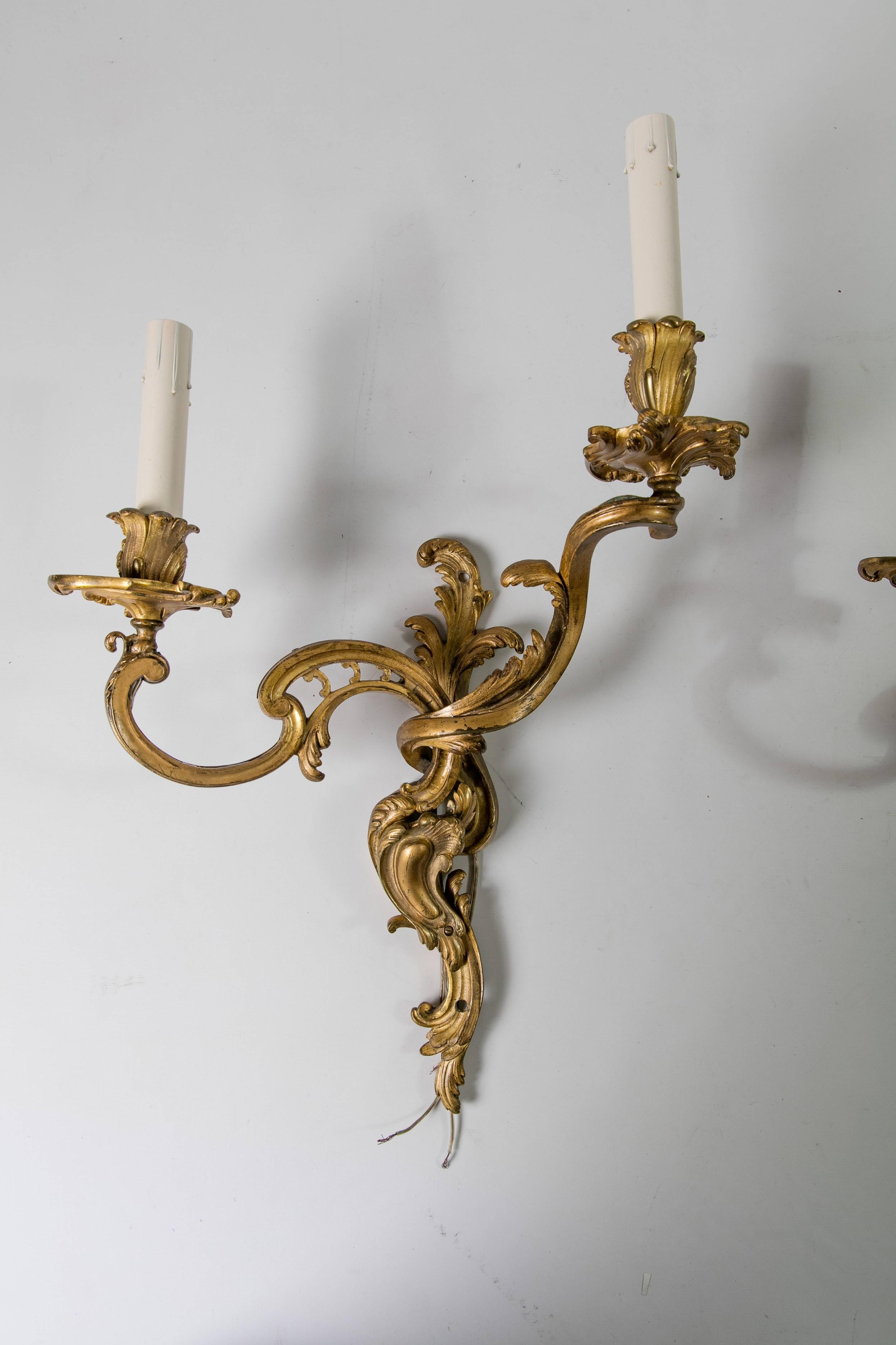 A pair of late 19th century gilded bronze wall sconces from France in the style of P. E. Guerin. The sconces are in the Rococo style and have been newly electrified. Each sconce takes two 40-watt max bulbs. The backplate of each sconce has screw