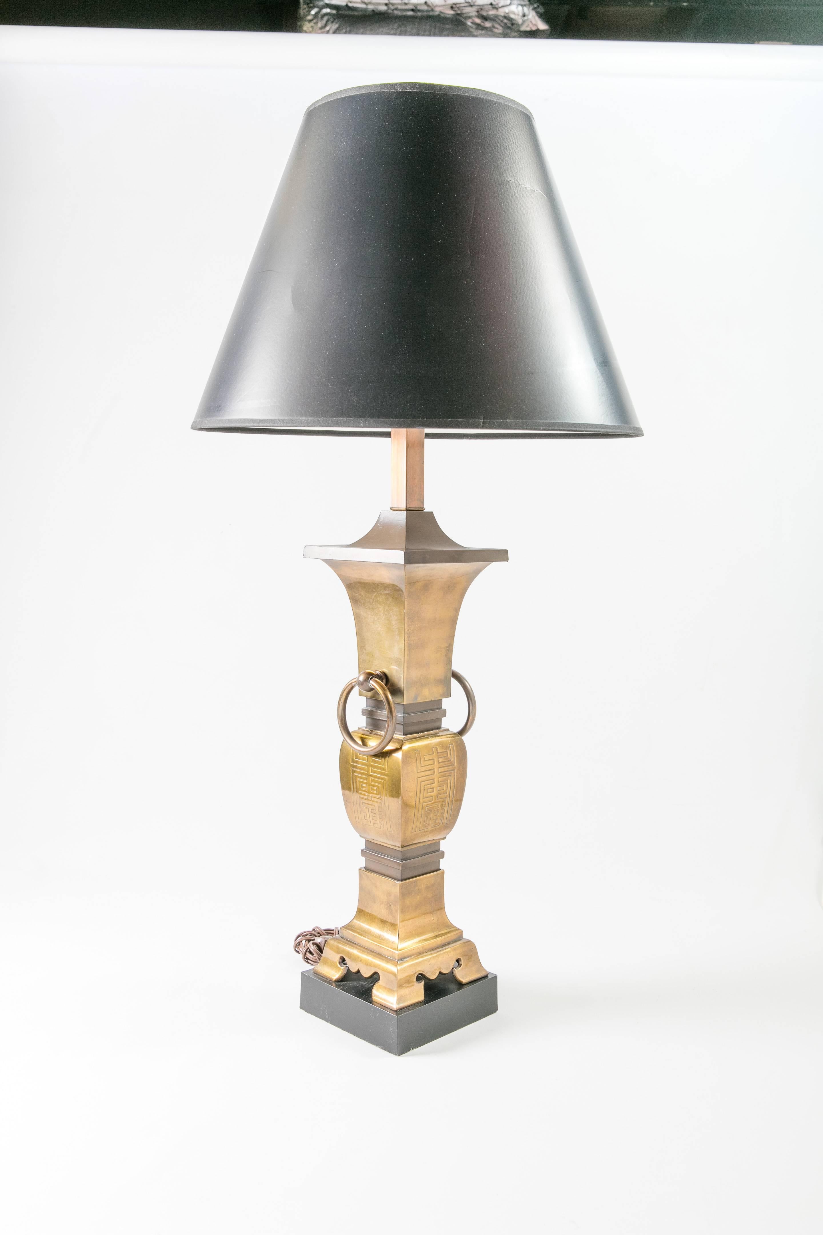 1960s heavy brass lamp with embossed Asian style motifs. Black paper shade. Newly wired and working; 60W-max bulb. Measures: Shade, 9