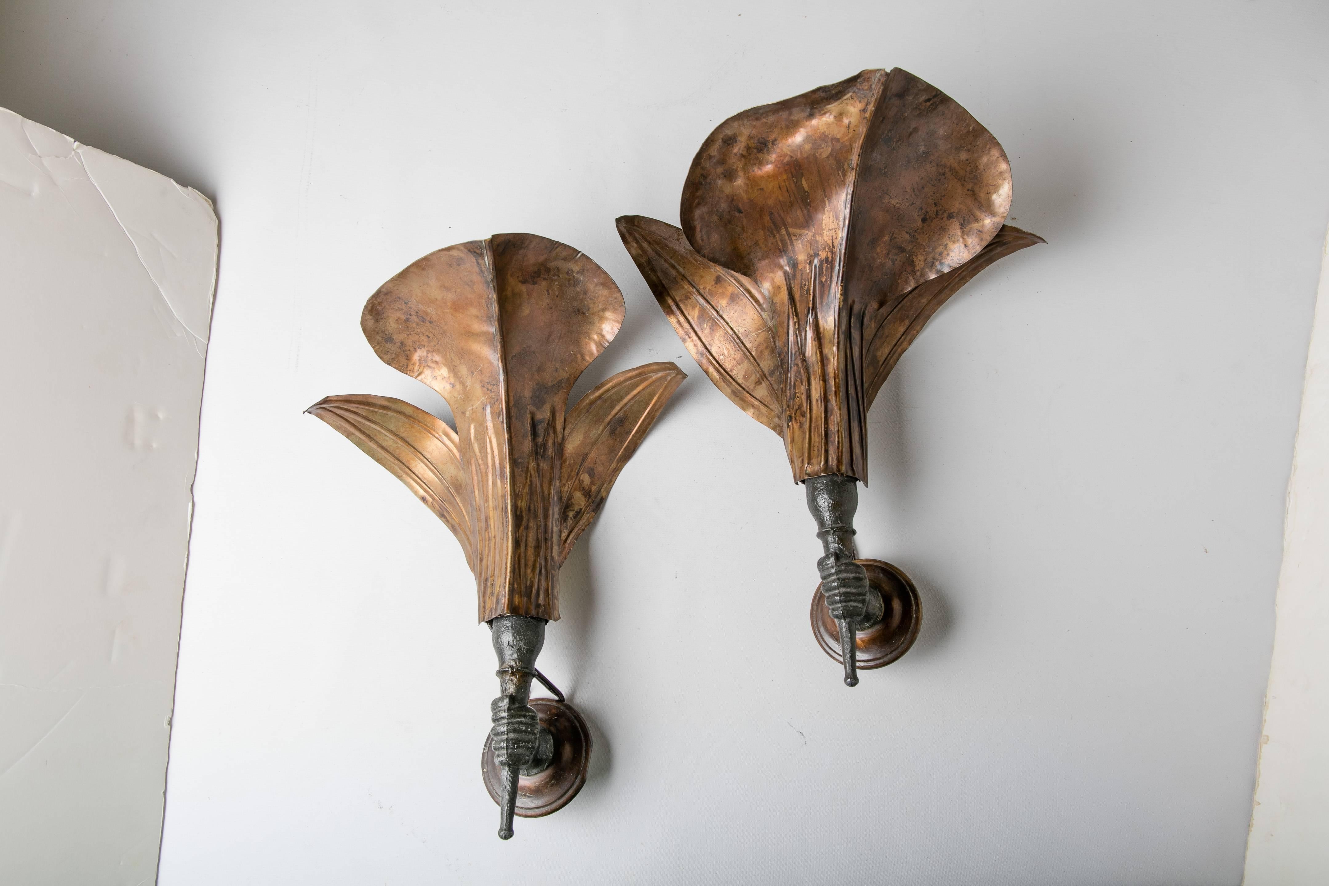 A pair of Italian Mid-Century lit sconces in the form of a hand supporting a palm branch. The hands are made from cast bronze, the palm leaves from pressed copper. Each sconce is newly wired for the US and features a socket sized for a standard-size