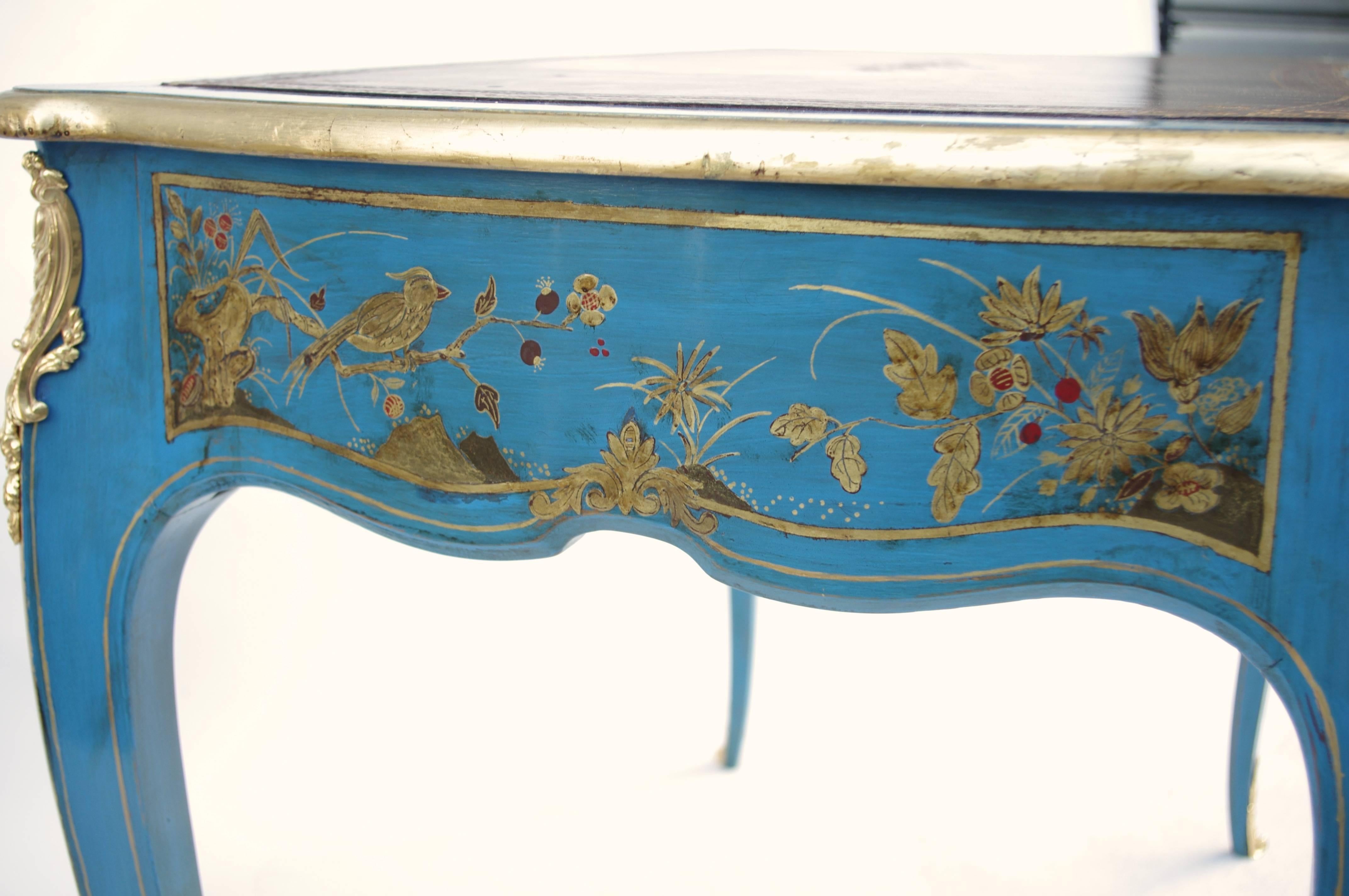 Louis XV style.
Chinese gilt decor on blue lacquer.
Gilt and chiseled bronze.
Dark top brown leather.
French work, circa 1900.