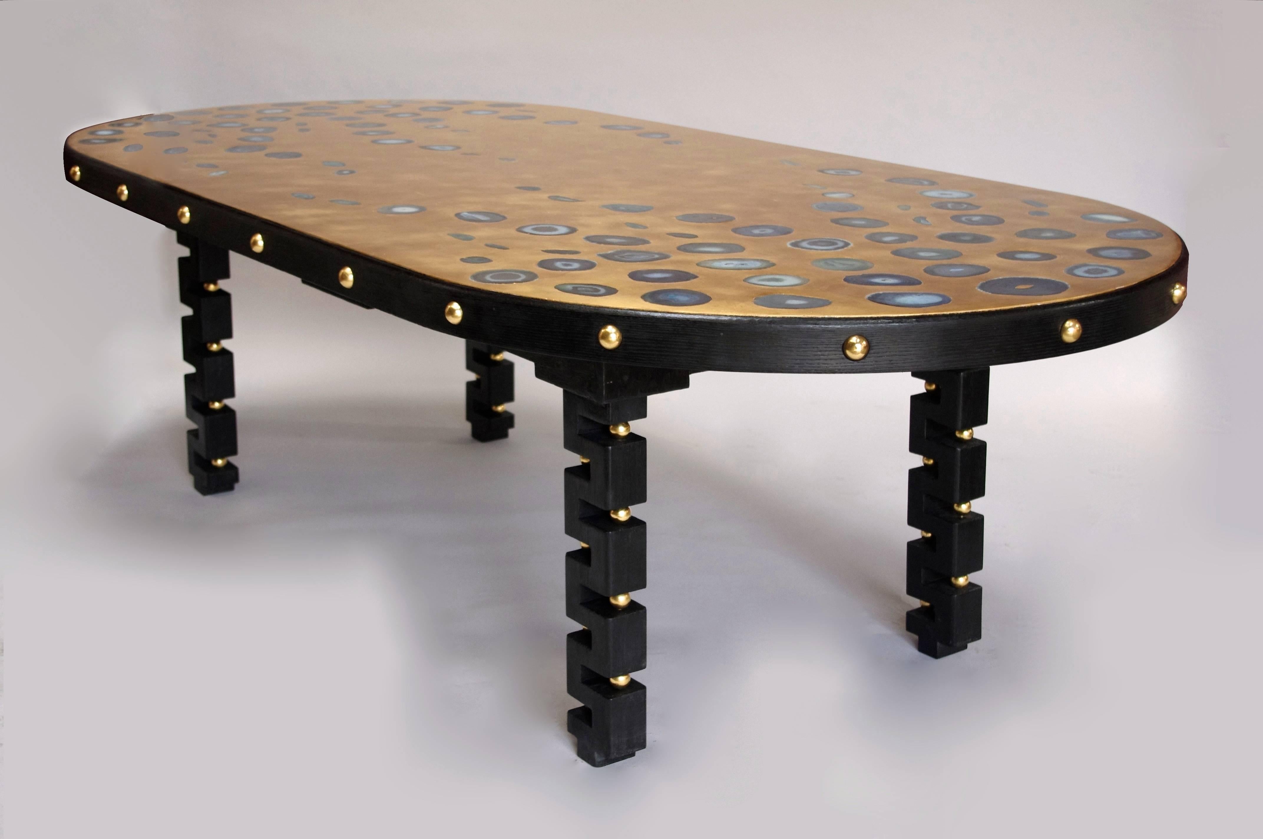 Large oblong shape table with blackened oak structure of the 1970’s. Standing on four solid legs carved in meanders form and decorated with gilt wood balls inlaid in the apron and empty spaces in legs.
Gilt tray with gold leave, adorned with agates