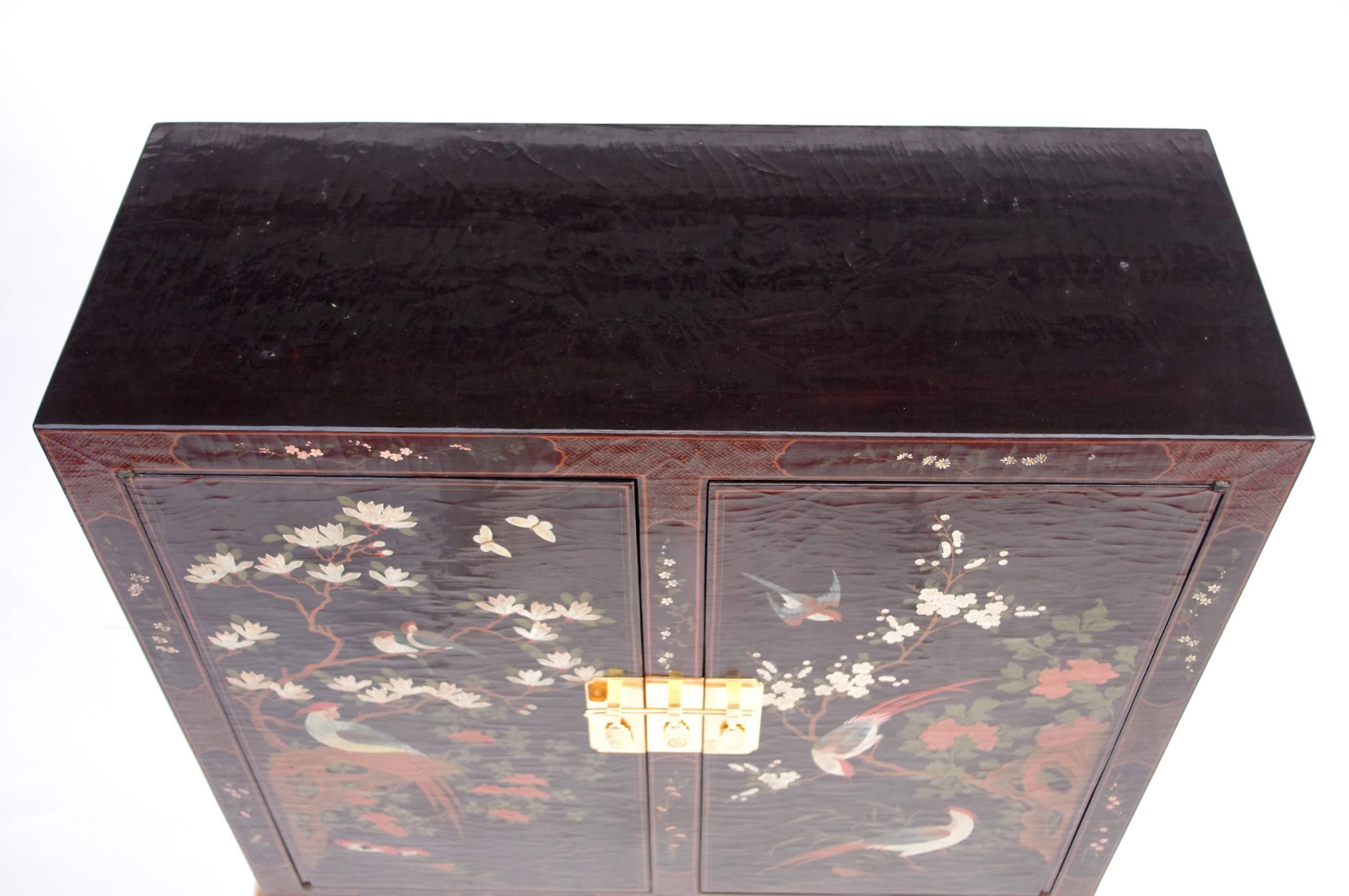 Chinese style lacquer.
Standing on Louis XV style gilt base.
Opening on two doors.
Mirror inside and a shelf in glass.
Foliage and birds decor.
Work from 1950.