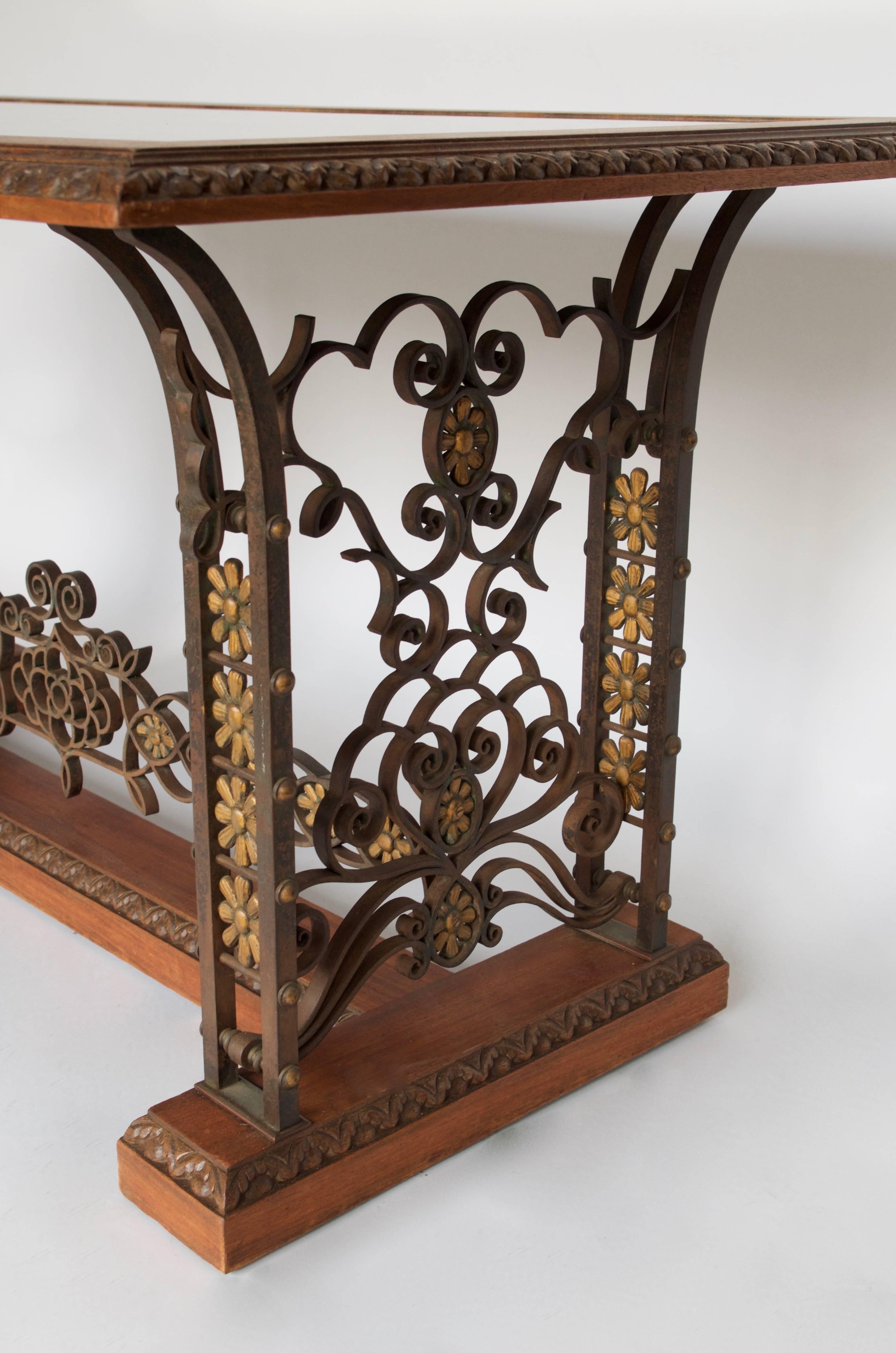 Finely worked wrought iron feet
Decoration of interlacing and gilt flowers
Molded and carved mahogany
Oxidized mirror top
Work of the 1950s.

 
