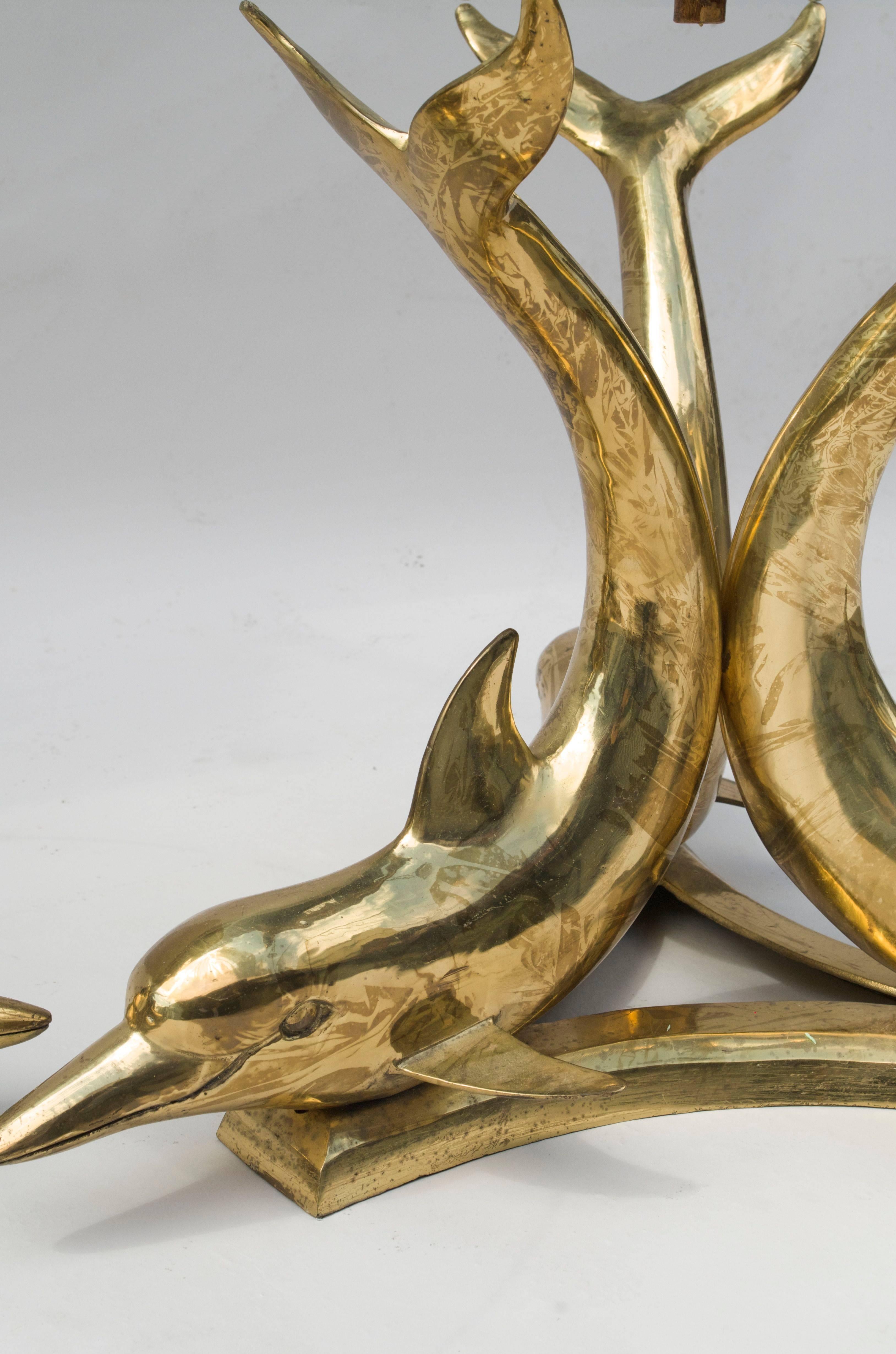 Base decorated with three dolphins
Round glass top
Gilt brass
Work circa 1970.
 