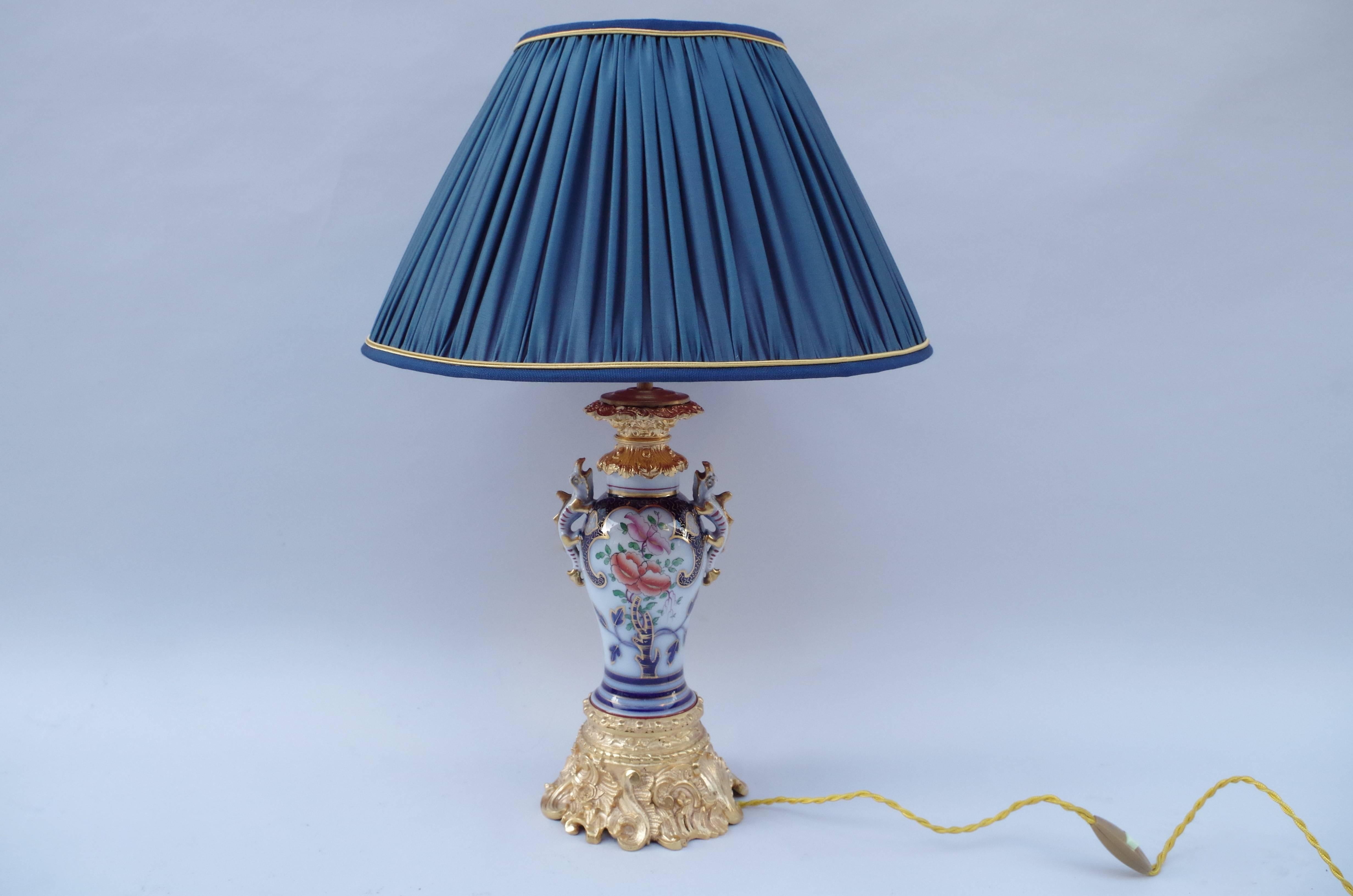 Pareja de lámparas de porcelana Valentine con dos pequeños lezardos en los laterales formando asas. Porcelana decorada con flores de color azul cobalto y reflejos dorados, característica de la porcelana Valentine.
Montura cincelada y dorada estilo