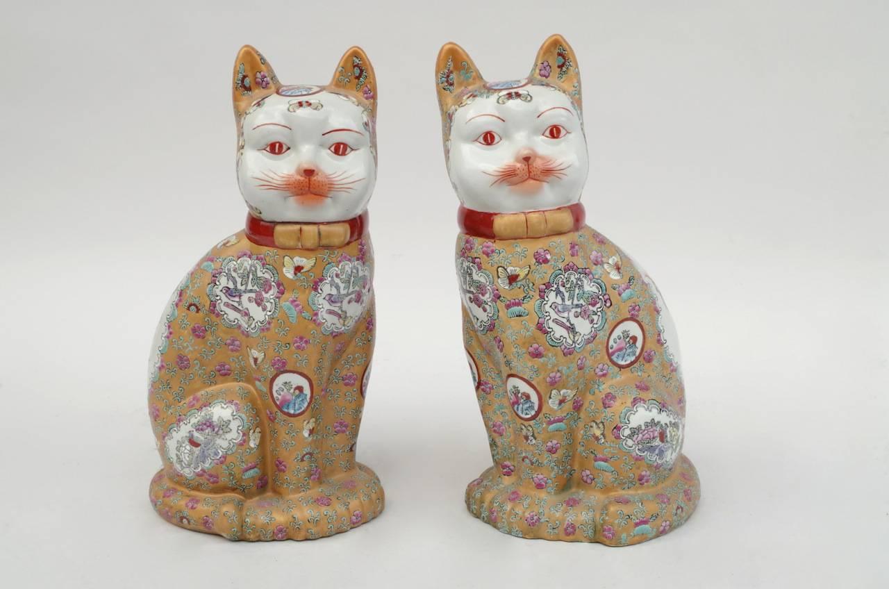 Ein Paar Skulpturen aus Porzellan im Kantonsstil, die zwei sitzende Katzen darstellen. Weißer Fond mit emailliertem gelbbraunem Dekor und Blumen- und Pflanzenmotiven in Grün-, Rosa- und Rottönen, Kantonsporzellan-Stil.
Chinesisches Werk, realisiert