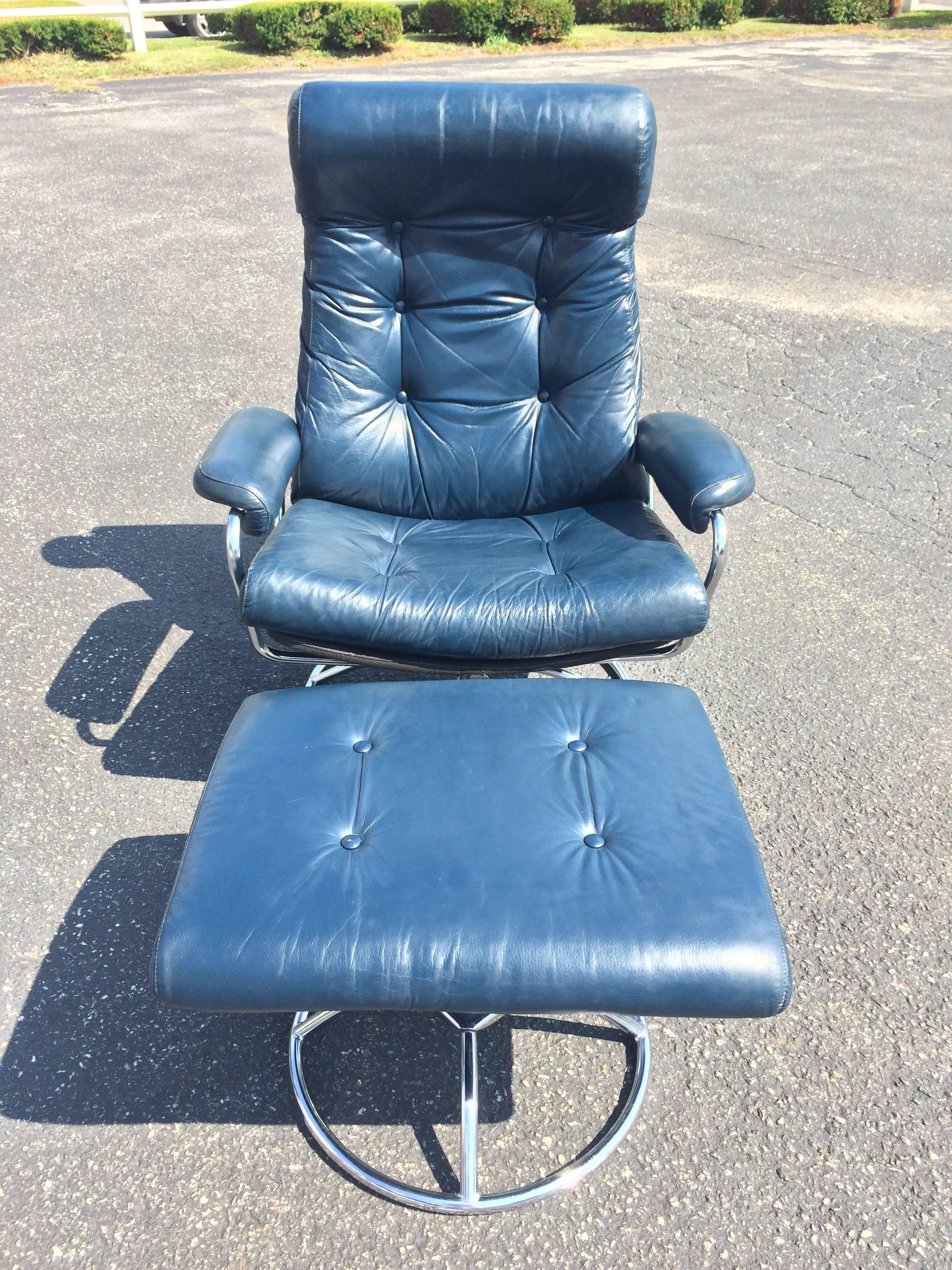 Recliner lounge chair and ottoman in navy blue. Recliner is adjustable from upright to full recline and swivels. This ergonomic recliner comes with matching ottoman. The backside of the recliner is covered in a canvas upholstery. The recliner back