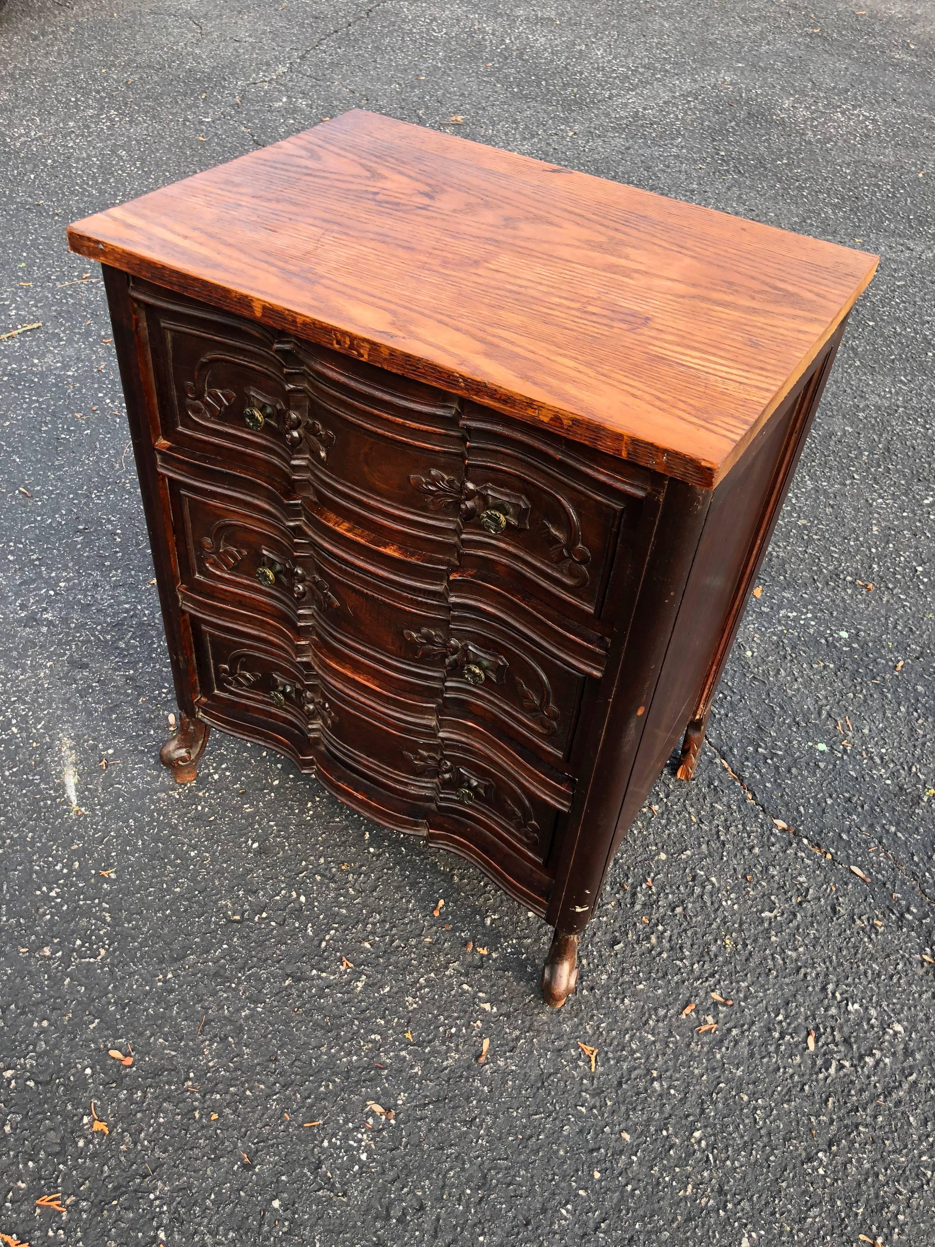 Carved Front Three-Drawer Chest. The solid oak top has been married to the base and the feet may not be original. Distressed, but all in all a pretty piece. This would make a sweet nightstand or side table. 