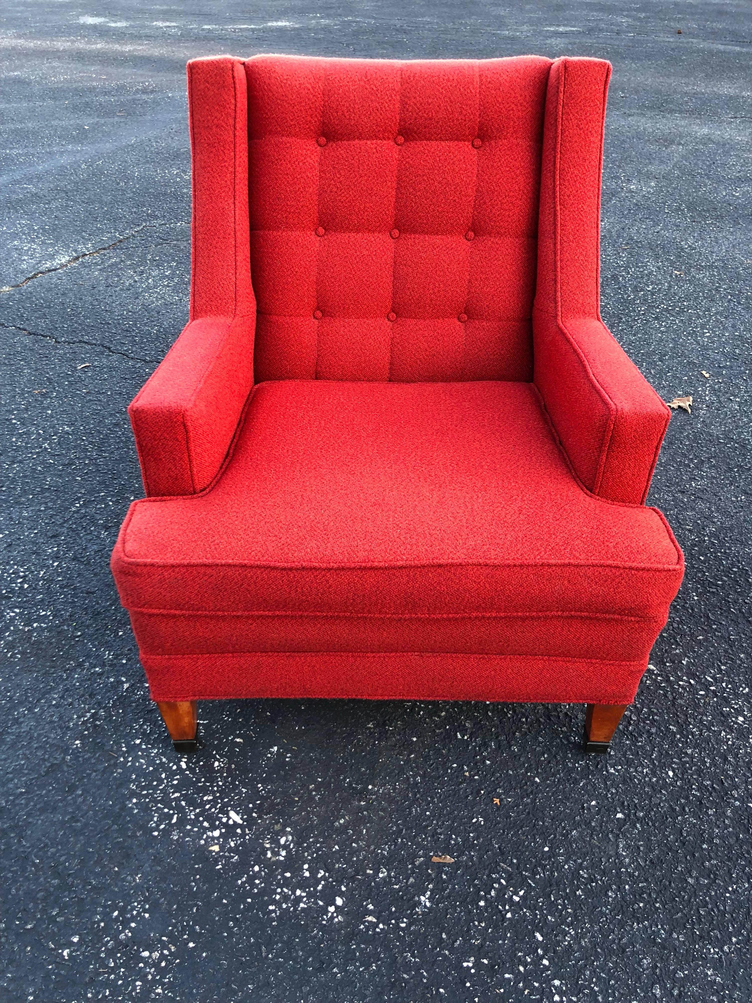 Mid-Century lounge chair in red. Tufted button back with simple tailored lines make up this Classic chair. Great for bedroom, living room or office. Solid, heavy construction. Wooden legs with adorned metal front feet.
 