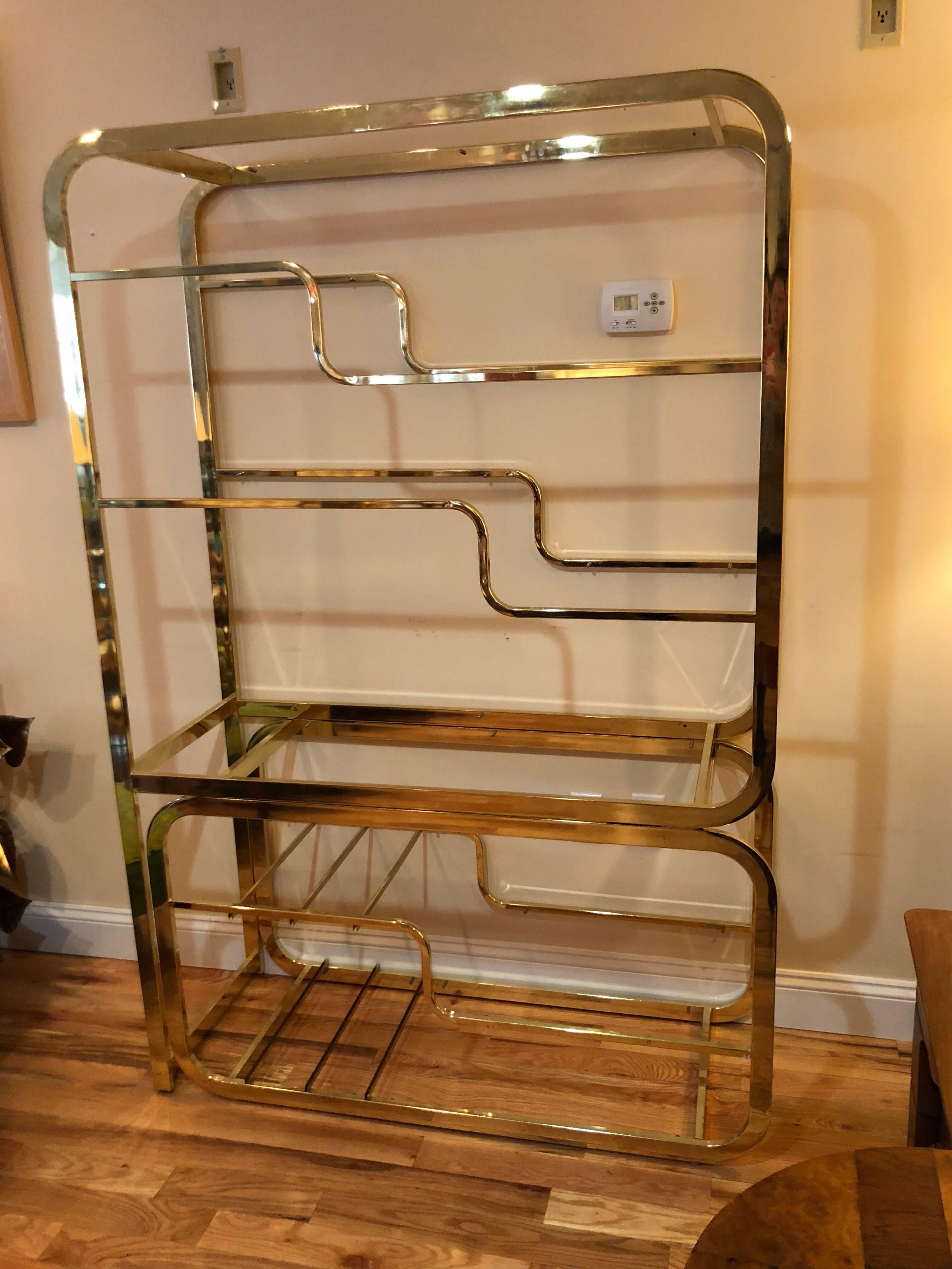 Milo Baughman Design Institute Of America brass and glass etagere. Glass shelves line this brass beauty. Lower adjustable section which slides out. Signed Design Institute of America.