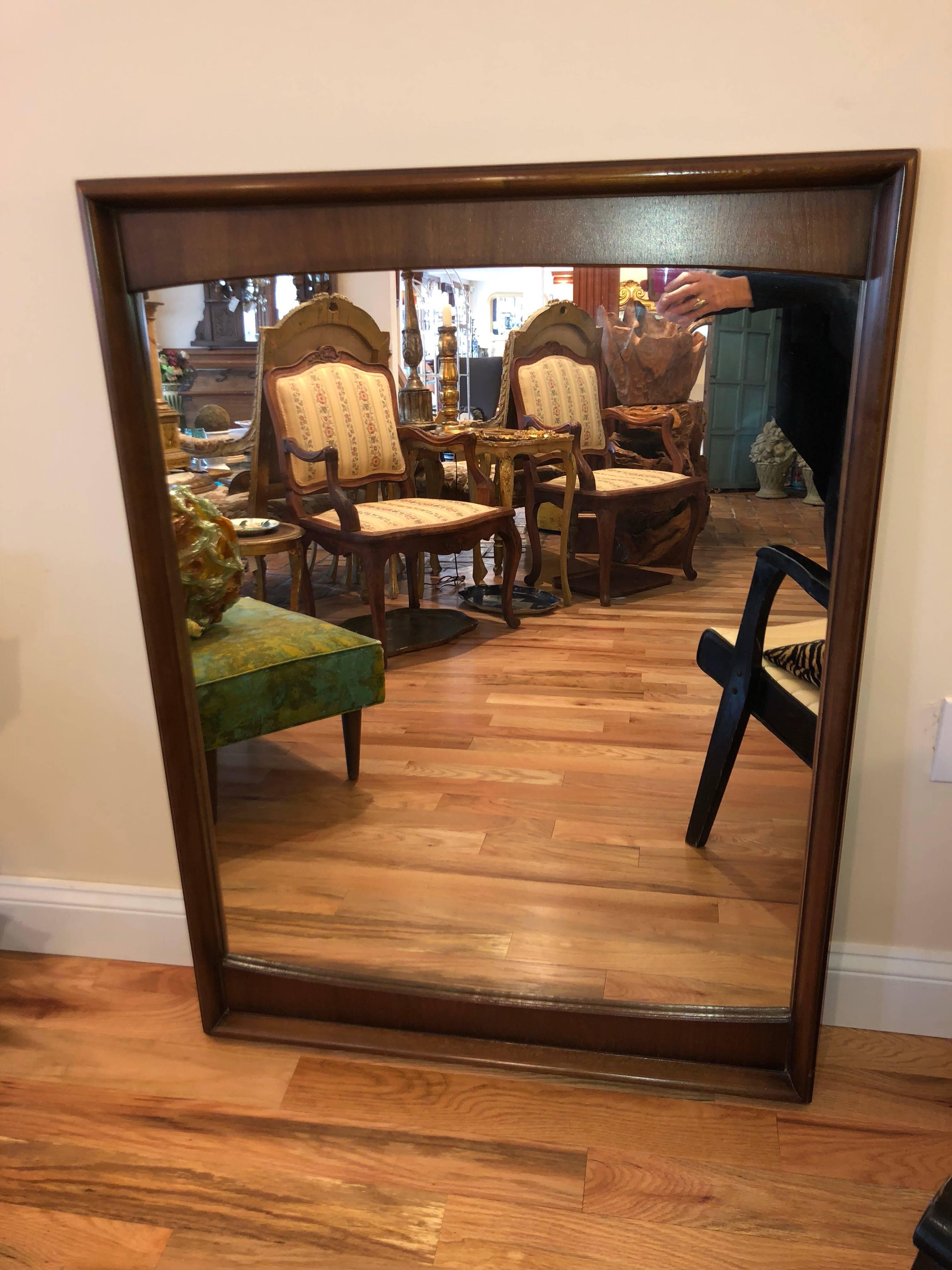 Mid-Century Modern walnut mirror. Somewhat bow-tie shaped, this mirror would look great over any mid-century table, dresser or in a bathroom. Reduced for clearance