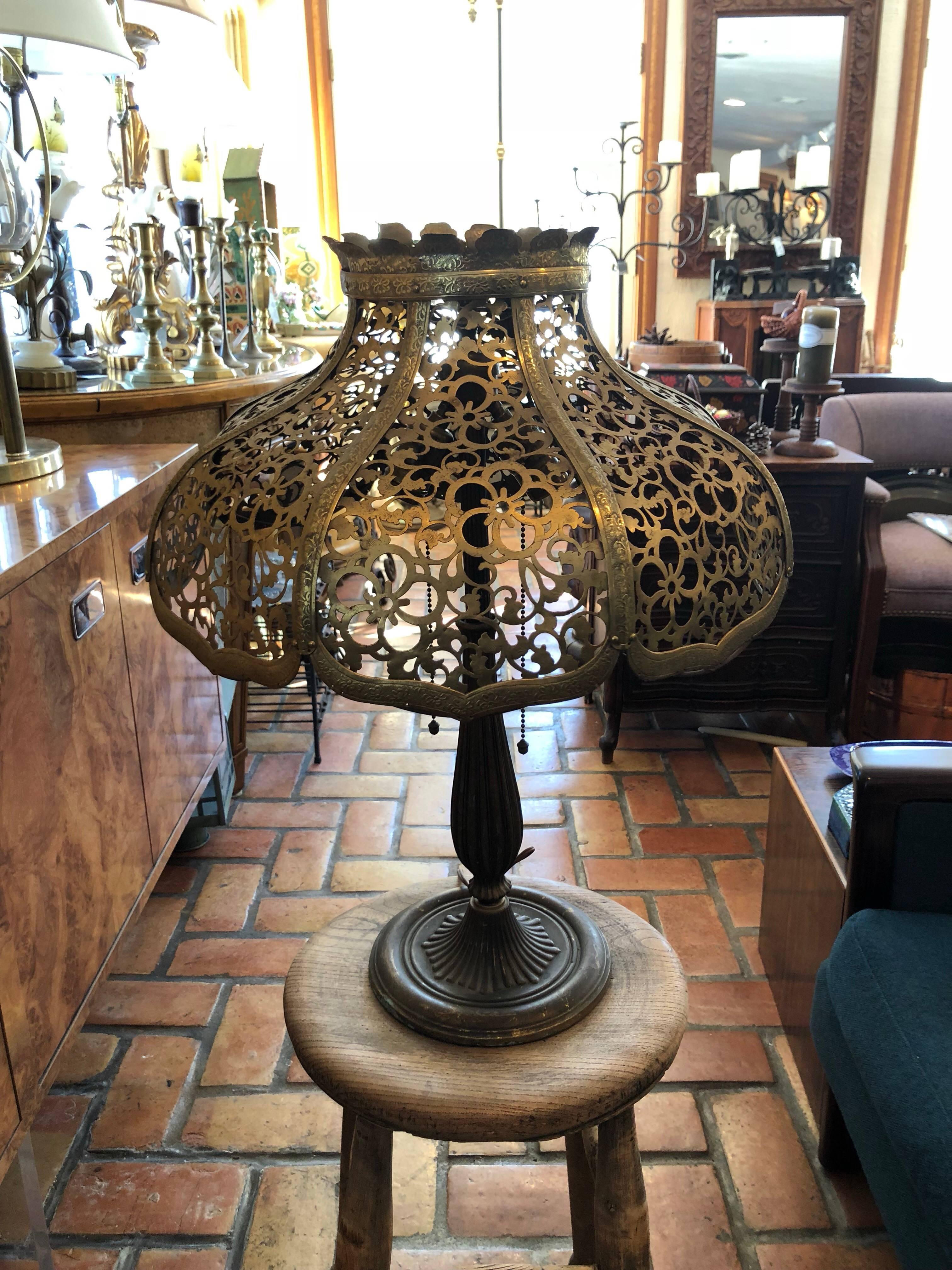 Antique gilt metal lamp with pierced shade by Edward Miller.
Lamp base signed E.M.Miller. Not sure if shade is original to base. 
Pierced shade may have originally been silk lined. Stamped 1150 underneath. Double socket with pull chains. Measures: