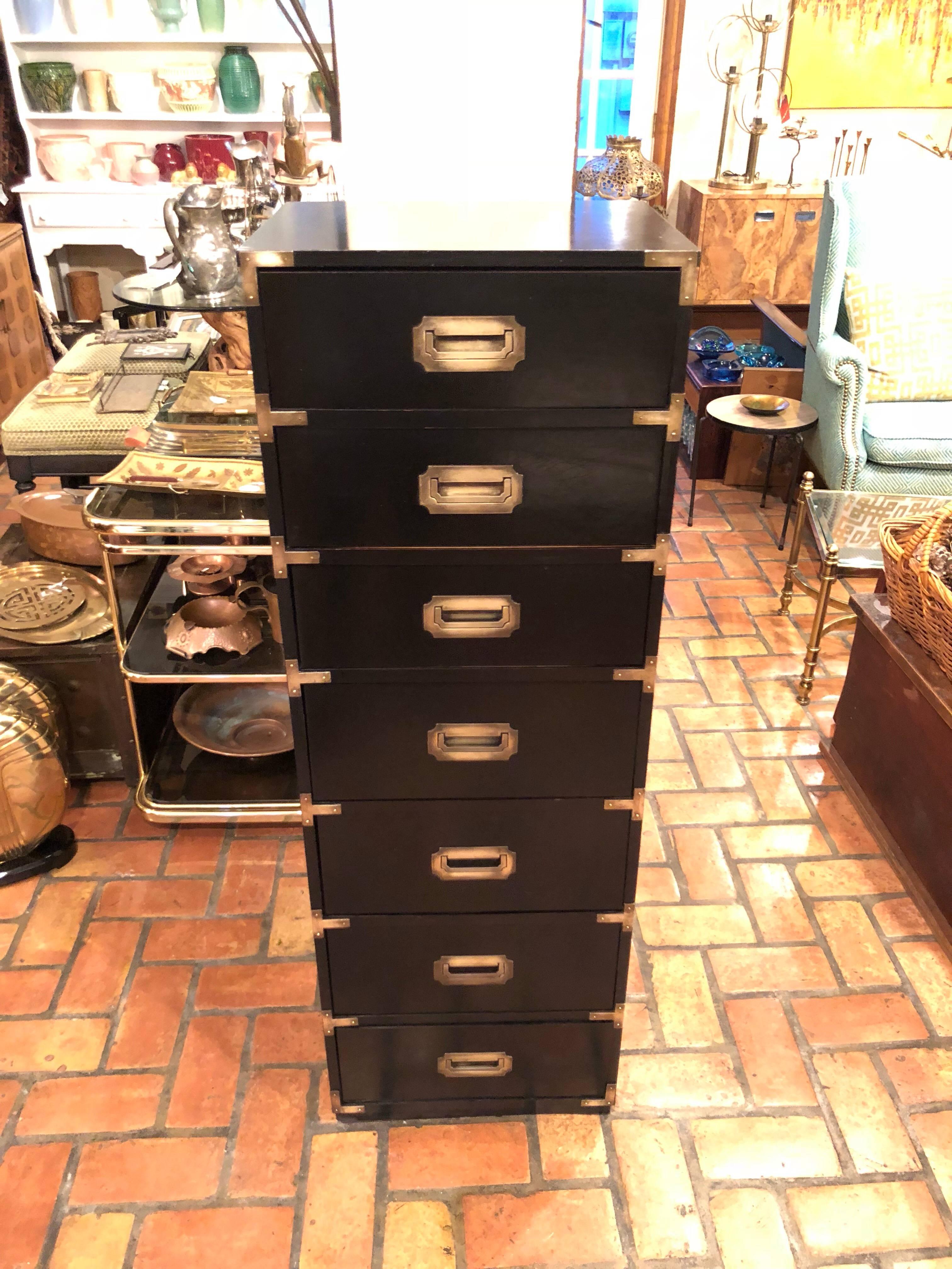 Tall Black Campaign Chest of Drawers with Brass Accents. Also could be called a semanier, as it has seven drawers. Nice upright and tall decorative pieces. Great for storage. Interior of one drawer has some wear to the inside. We may line them with