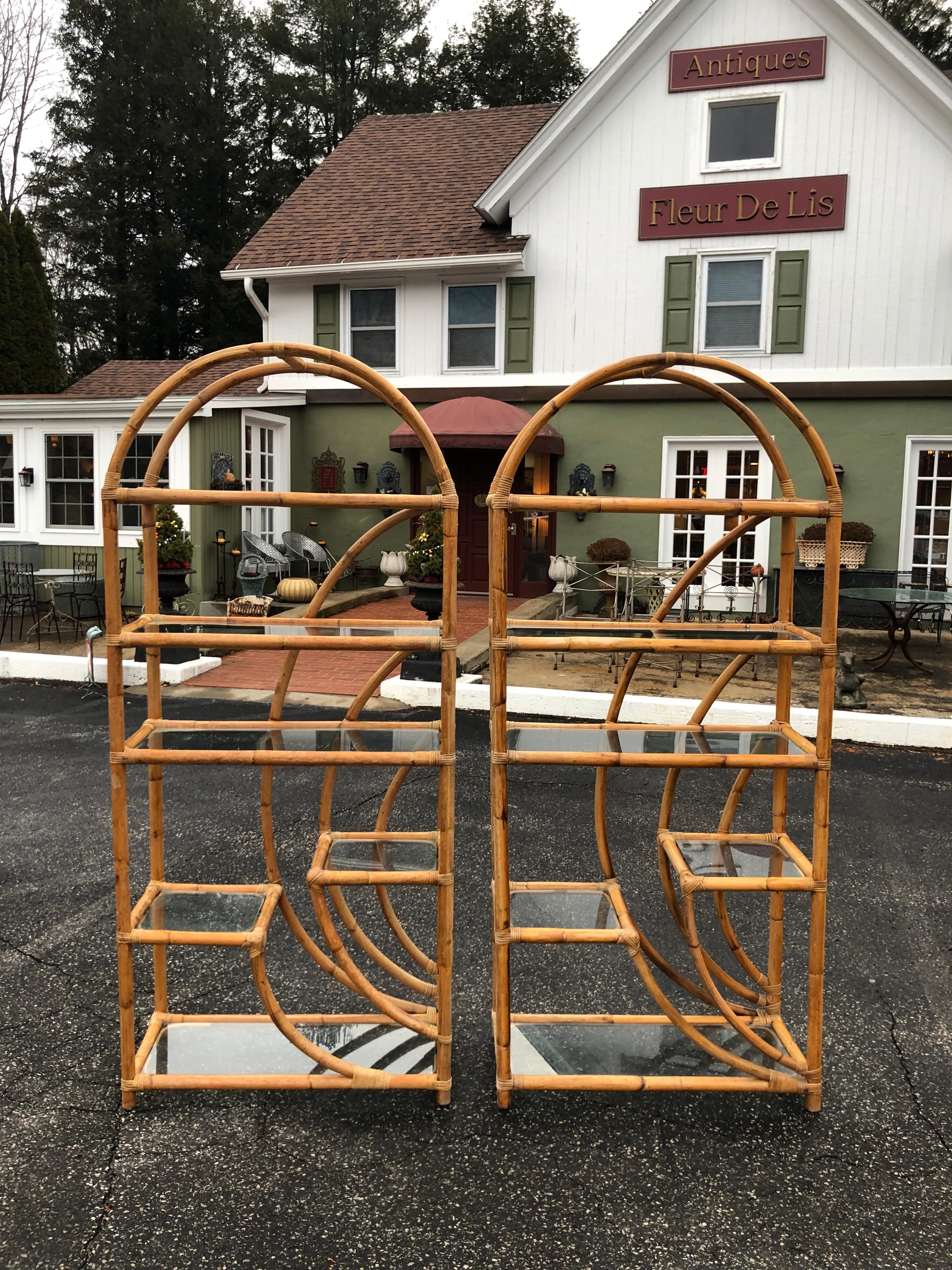 Pair of vintage Rattan étagères with six glass shelves each . Great Boho chic style. Nice curved top adds some flair to these beauties. Fabulous for display in a living room or bedroom. Great tropical feel to this set . Ideal for an island home.